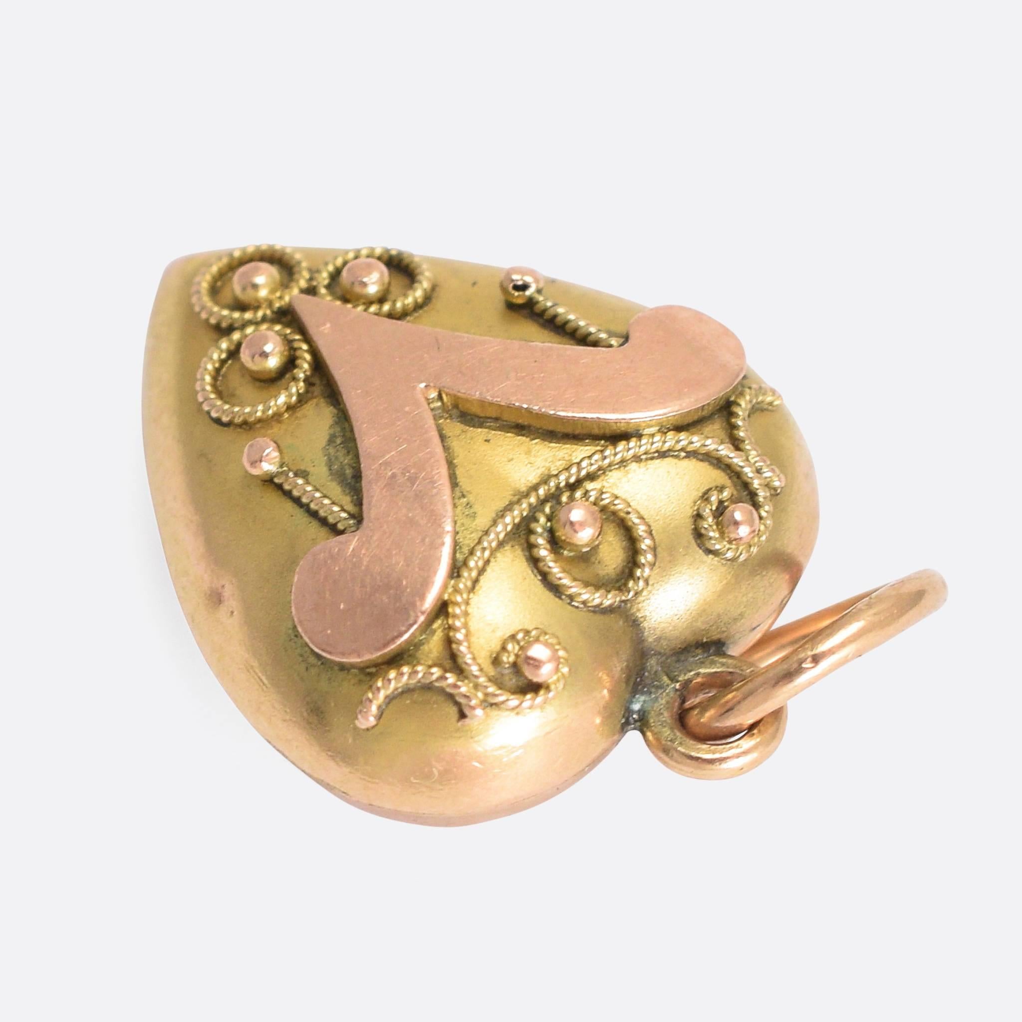 A sweet antique puffed heart charm, modelled in two-tone 9 karat gold. The body of the heart is yellow gold, with an applied rose gold V and Etruscan-style ropework detailing. A cute piece, more in the Victorian style than Edwardian, but it just
