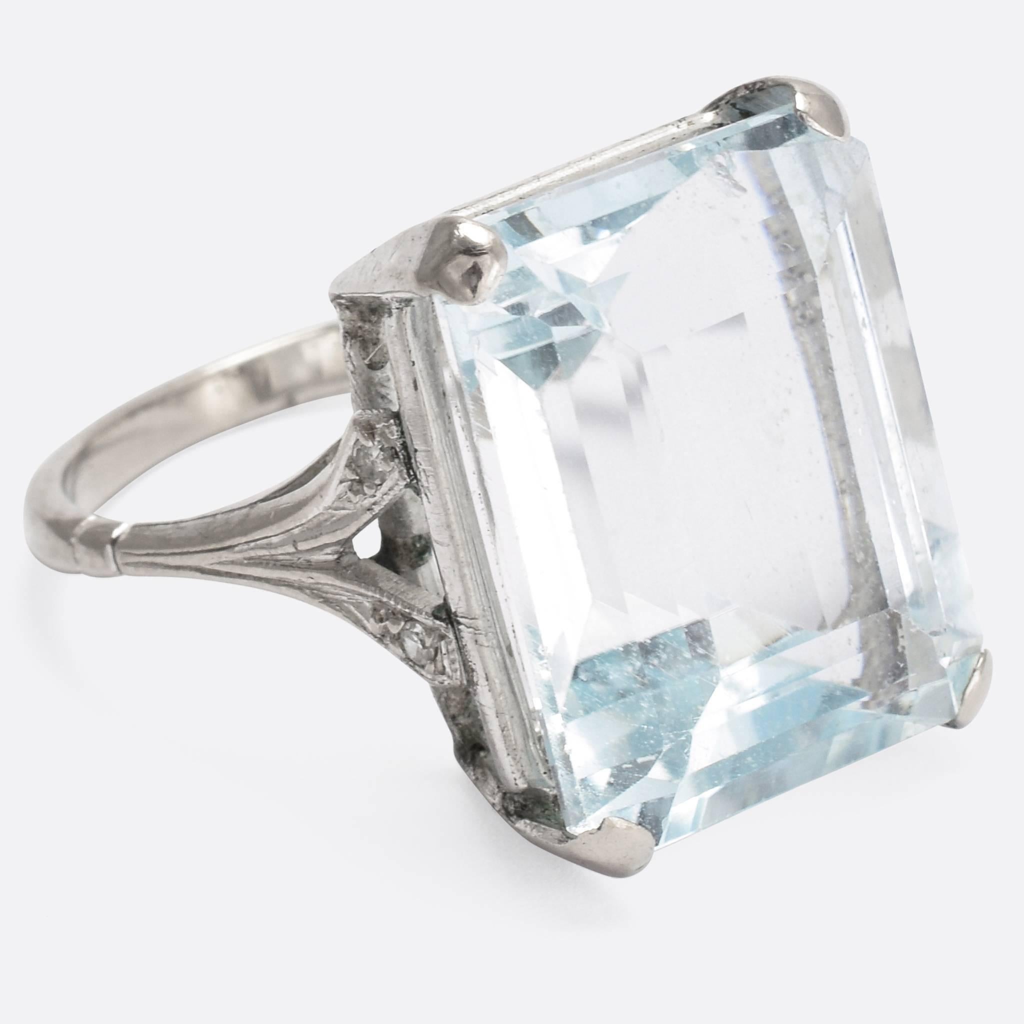A big and bold 1920s cocktail ring. The main event is a 15.3 carat Aquamarine, in a classic four-claw setting, flanked by four single cut Diamonds on elegant split shoulders. The stone shows a great pale blue colour, and excellent fire... An Art