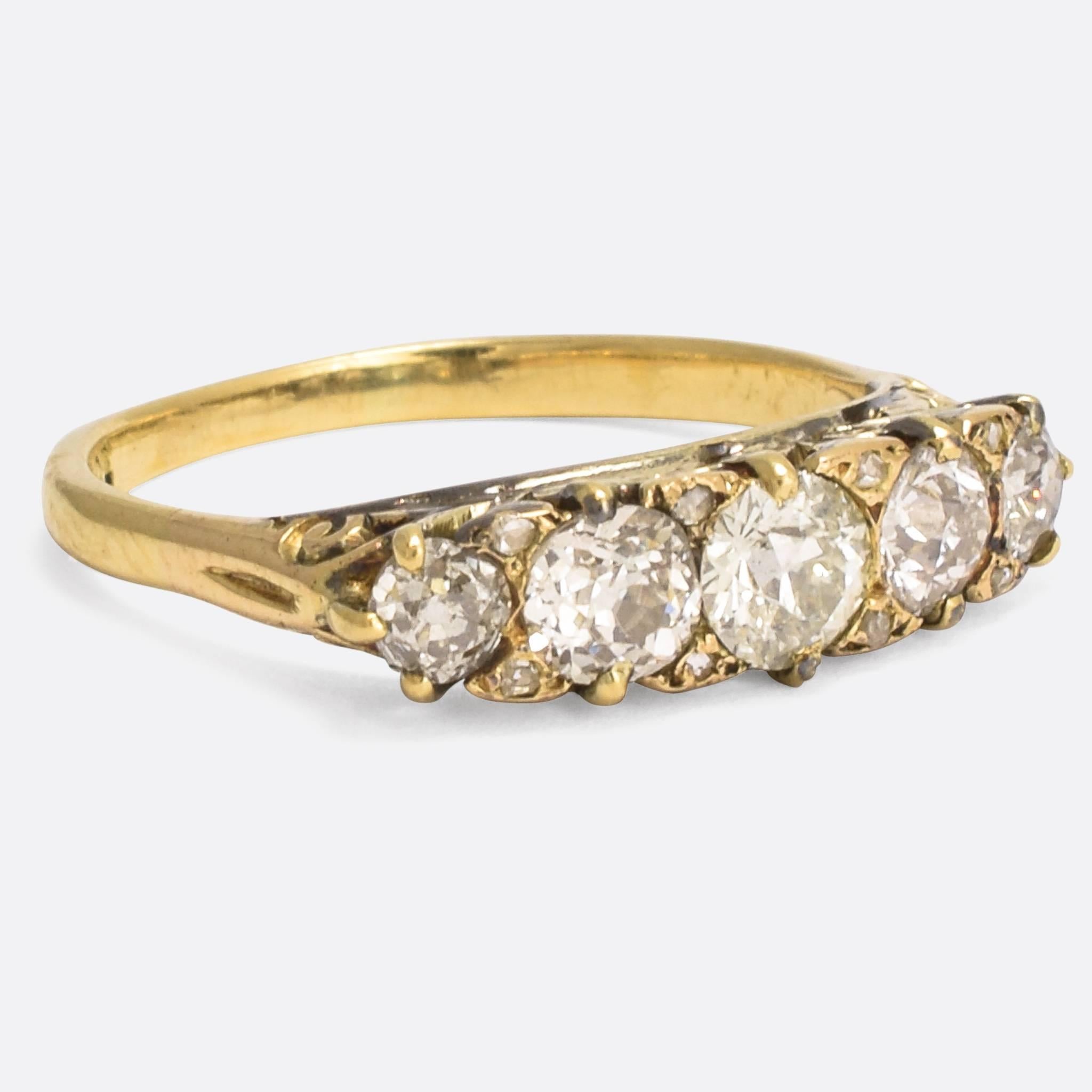 An especially nice quality mid-Victorian diamond 5-stone ring, with beautiful scrolled detailing to the sides and tiny rose cut diamond points in between the principal stones. The ring is set with a total of 1.75 carats of old European cut diamonds,