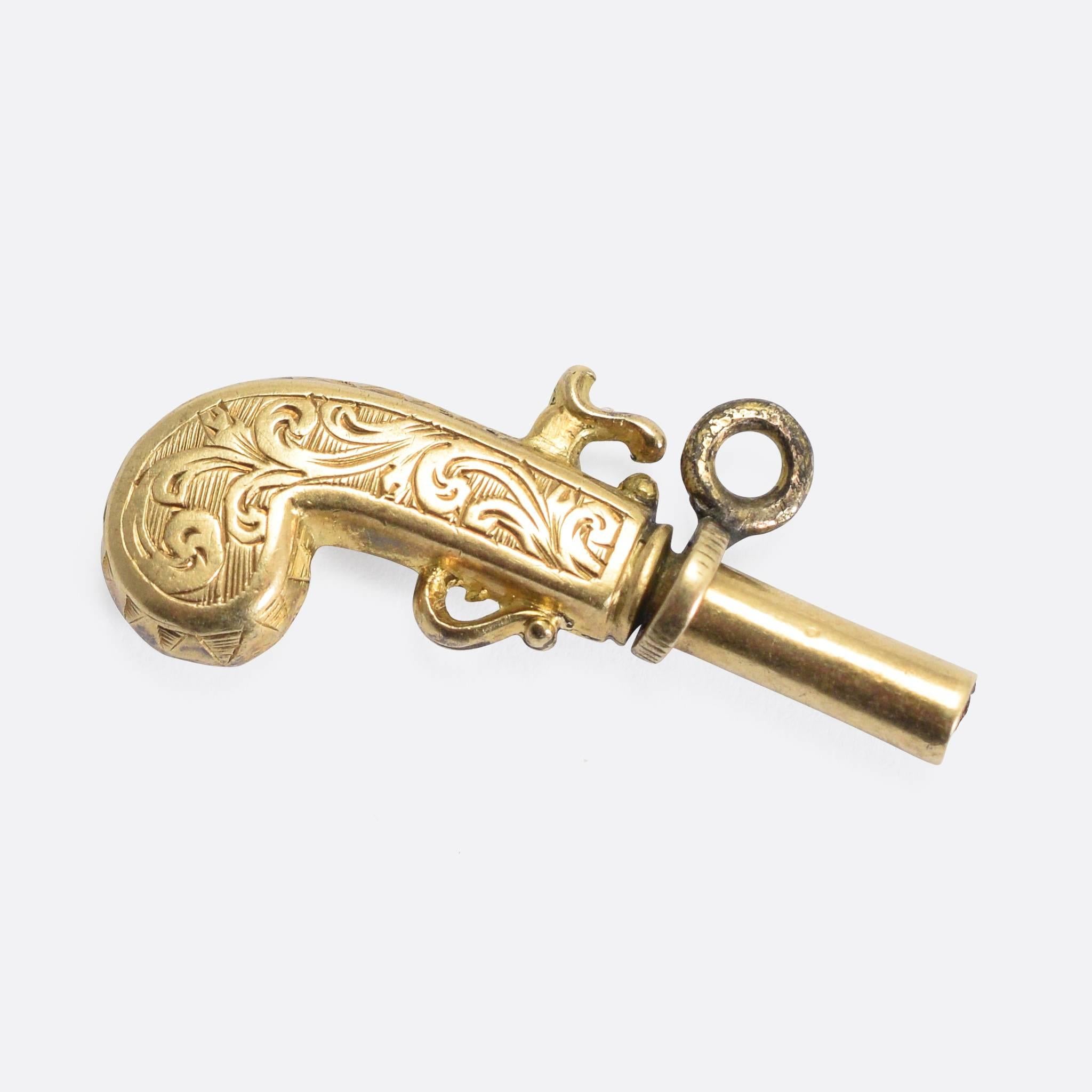 A cool late Georgian charm pendant, modelled as an 18th Century Flintlock pistol. It's crafted from 15k gold, adorned with ornate hand-chased detailing. It was originally intended to be used as a pocket watch key (see inside the barrel), but today