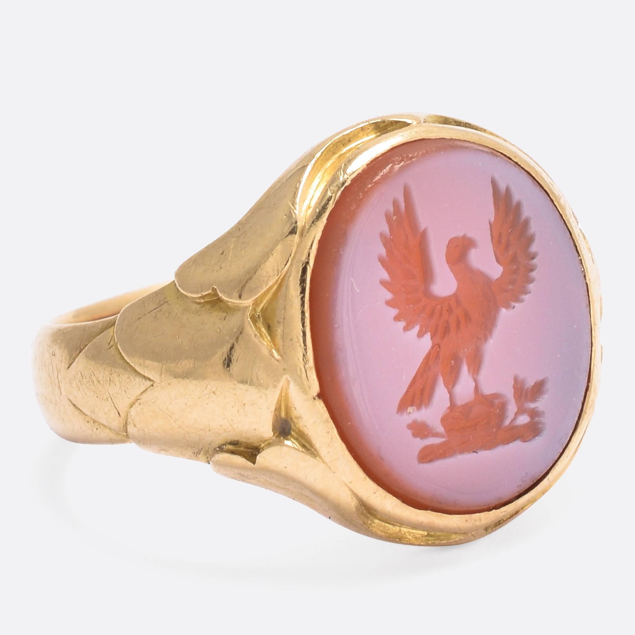 This antique signet ring has been carved with an heraldic intaglio crest depicting a hawk, with wings spread out, perched on top of an oak tree stump with tiny little oak leaves. According to Fairbairn's Book of Crest, this particular seal was used