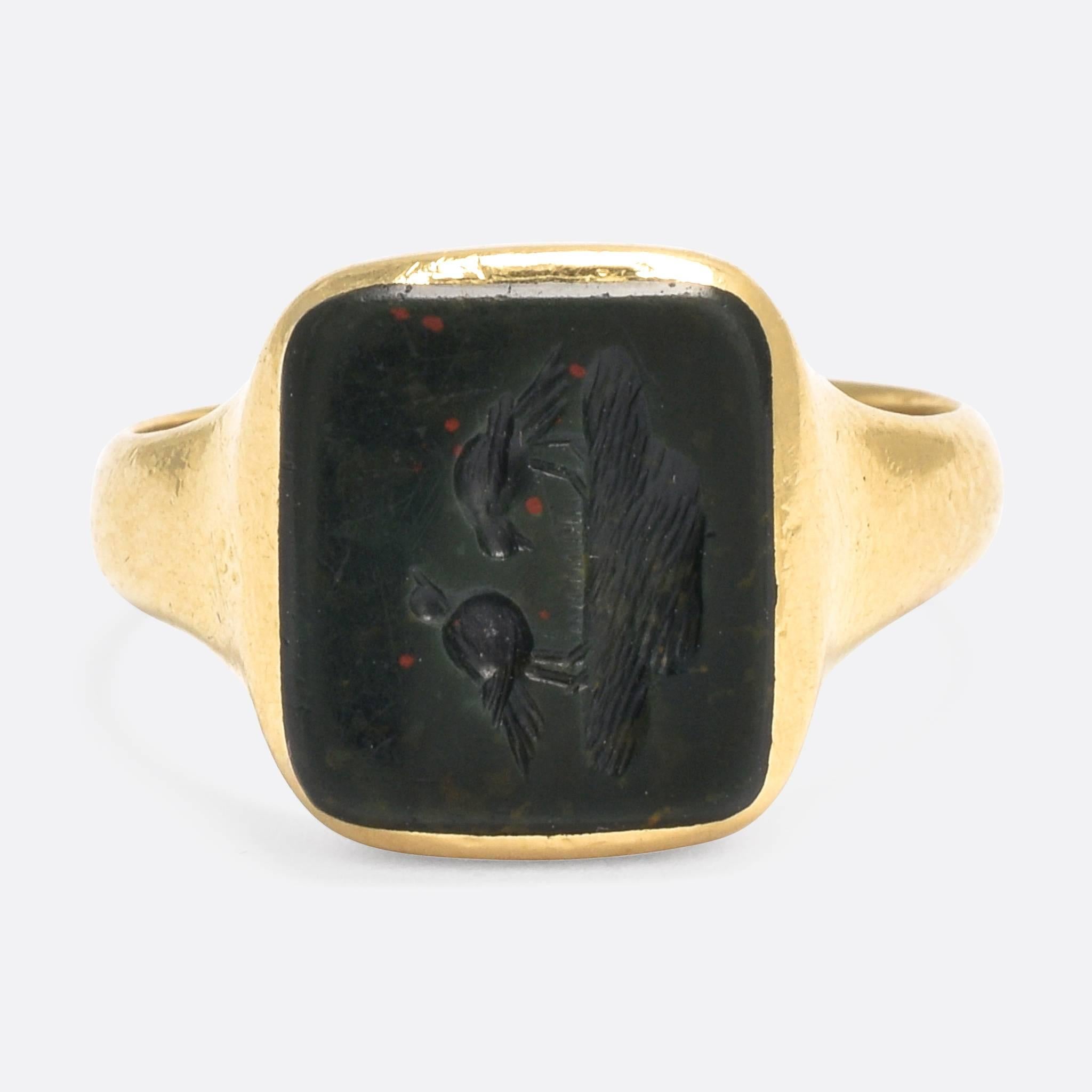 A cool and very unusual antique signet ring, set with a hand-carved bloodstone panel. The intaglio depicts two birds, bathing at a small pool of water... the detail is exceptional, and the subject is not the normal heraldry or monogram that we would