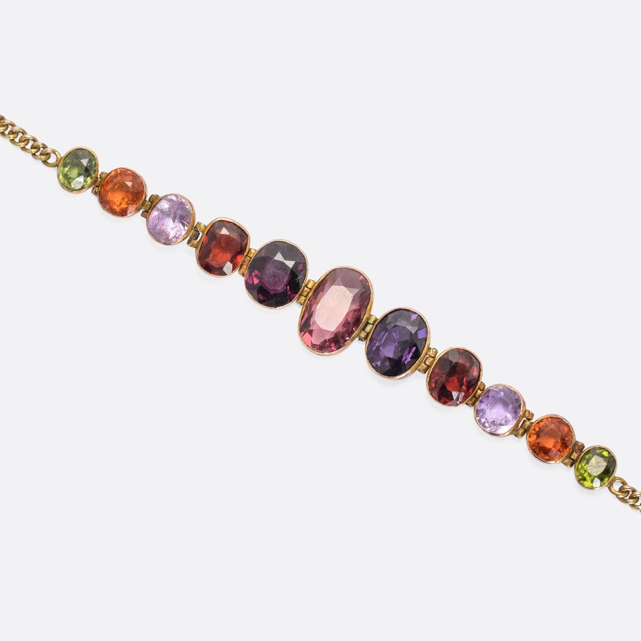 A superb antique multi-gem bracelet, dating to the turn of the 20th Century. A colourful collection of natural gemstones rest in fine collet settings, worked in 9 karat gold throughout. Each setting is individually hinged, allowing the faceted