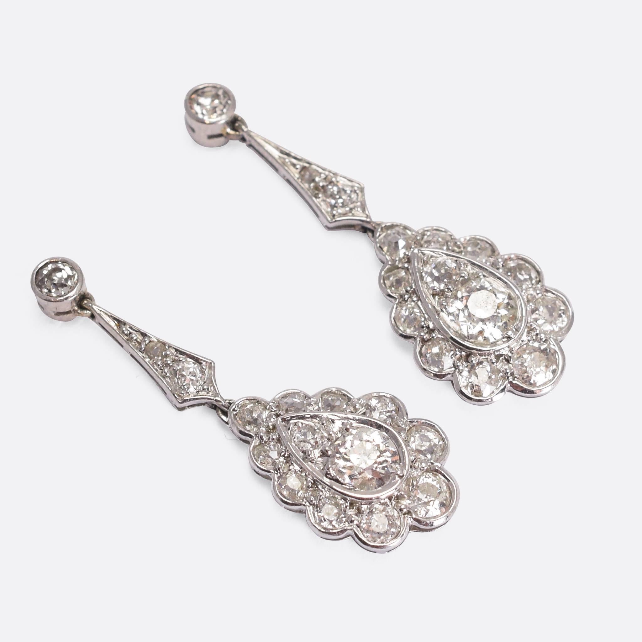 A stunning pair of Edwardian diamond drop earrings, modelled in platinum throughout and each ear set with just over 1 carat of diamonds. Pretty diamond petal-like settings surround central old mine cut stones - all clean and bright with excellent
