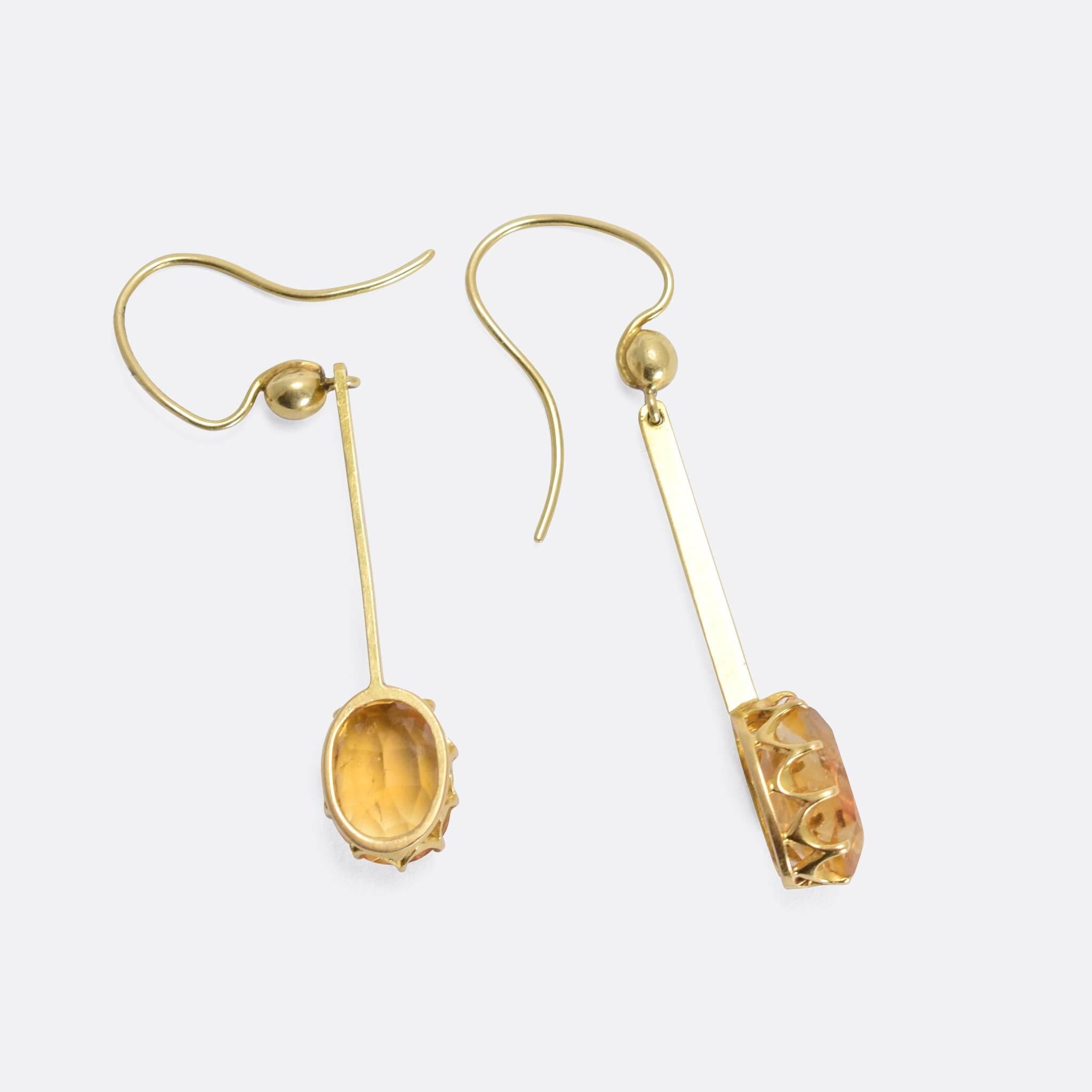 A fine pair of antique drop earrings, each set with a gorgeous oval faceted citrine. The stones rest in elegant claw settings, and sit at the bottom of a thin gold bar. A pretty pair of late Victorian gemset earrings.

STONES
Natural Citrine - each