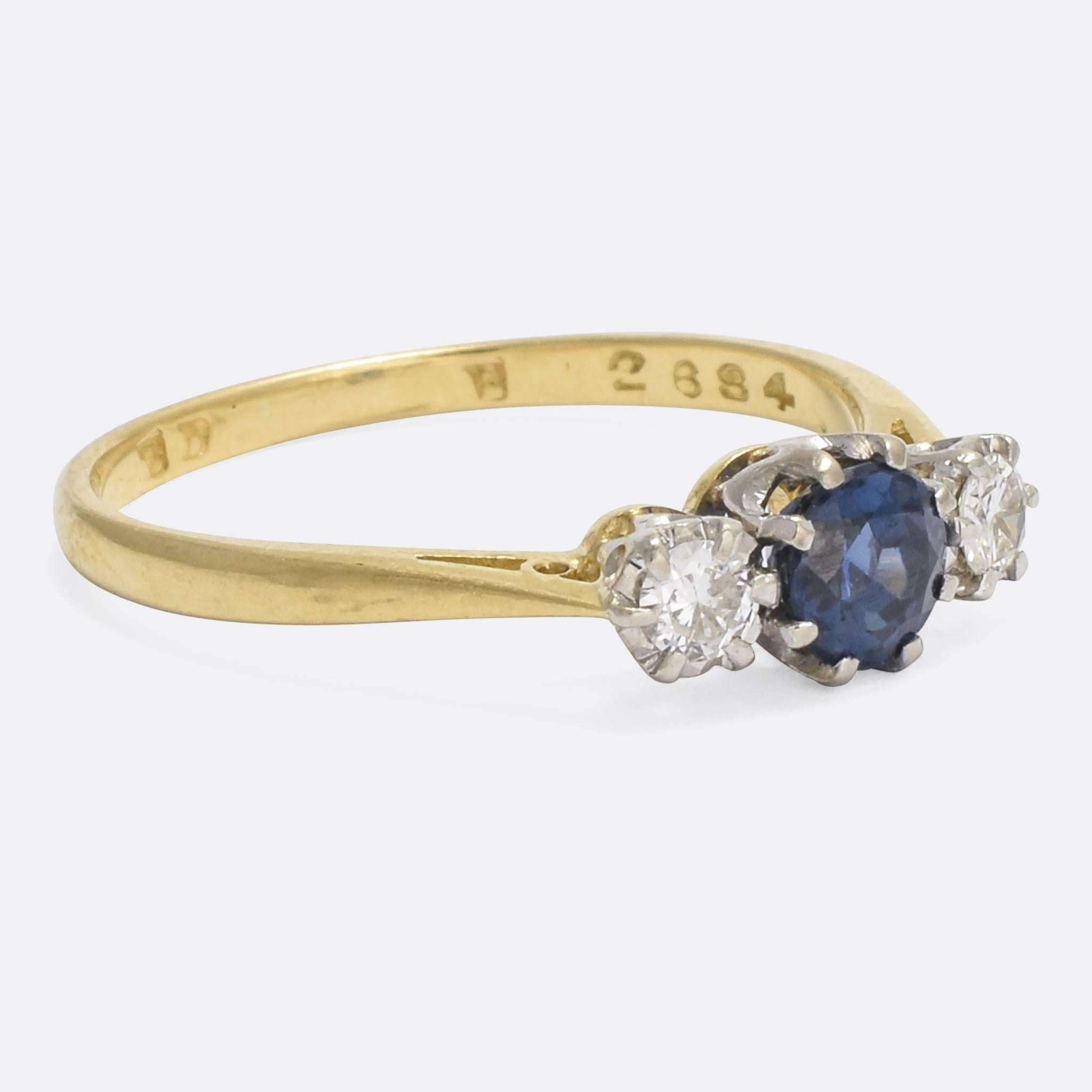 A sweet Edwardian three-stone ring, set with a central blue sapphire and two brilliant cut diamonds. With elegant pinched shoulders, the piece is modelled in 18k gold and platinum, and dates to the early 20th Century - circa 1910.

STONES
Natural