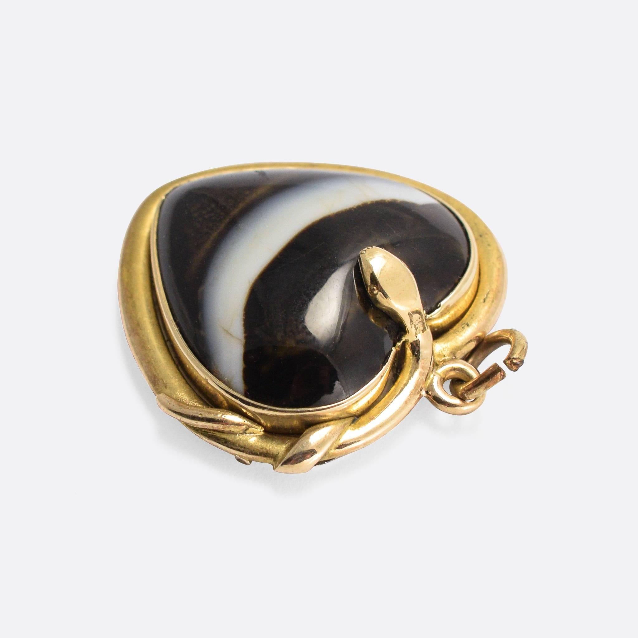 A cool antique heart pendant, set with a heart-shaped banded agate cabochon that rests within the coils of a golden snake... The pendant is a good size - a little over an inch wide - and the detailing to the snake's face is excellent. Modelled in 15