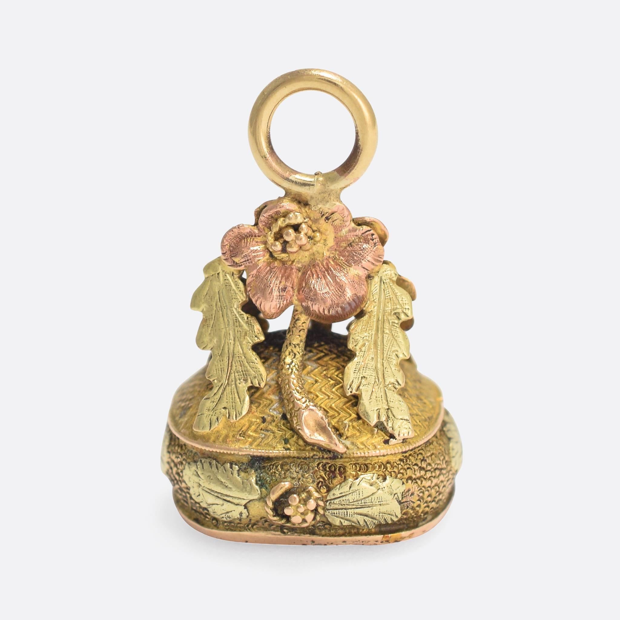 A beautiful antique fob pendant, unusually featuring a locket compartment in the bottom where we would expect to see a hardstone seal. The pieces has been expertly hand-crafted from three tones of 15 karat gold: yellow, rose, and green. The main