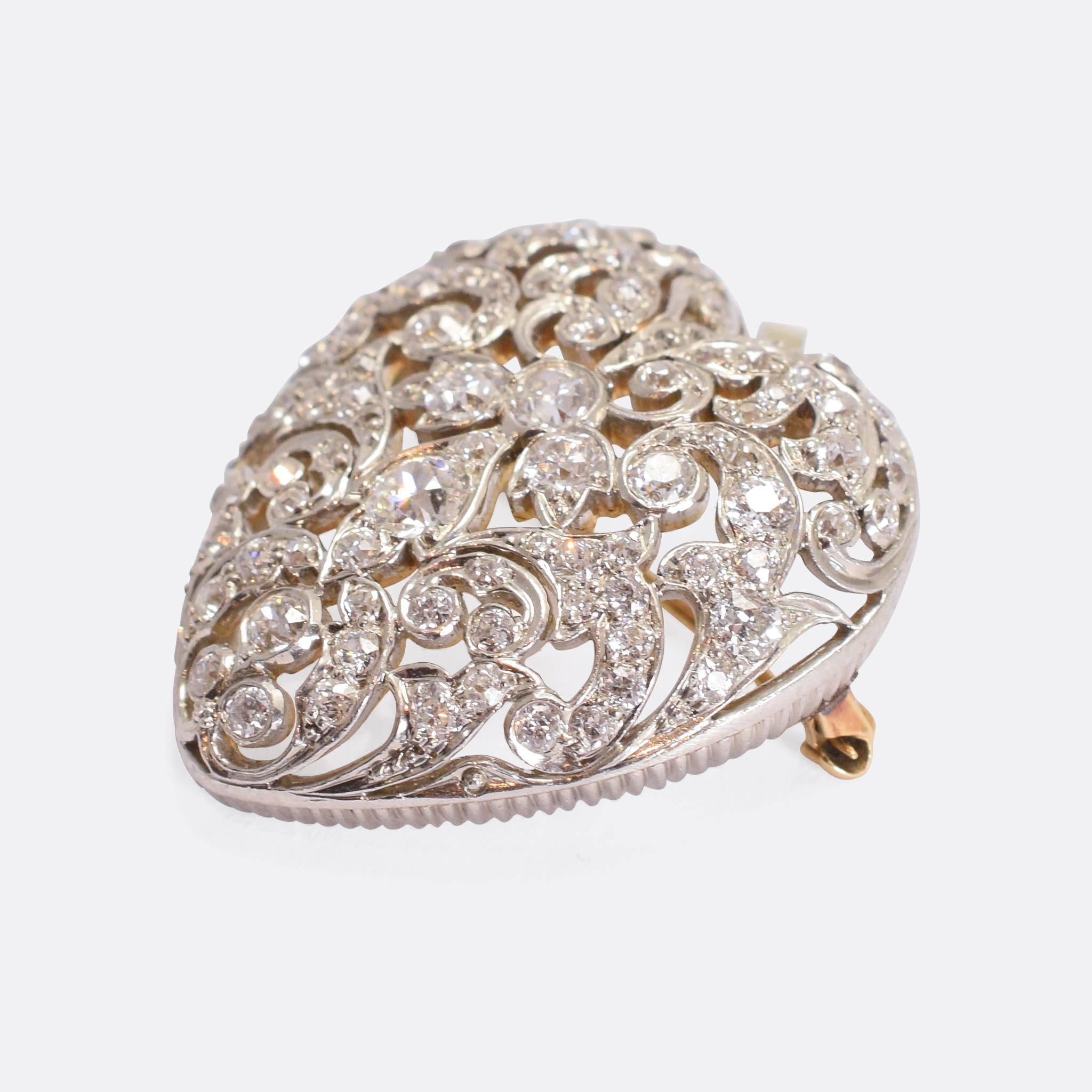 A stunning antique openworked heart, fully set with old cut diamonds. The craftsmanship is exquisite, modelled in platinum with 18k gold back, it dates to c.1910. The piece features a bail for wear as a pendant, and also brooch fittings. Set with