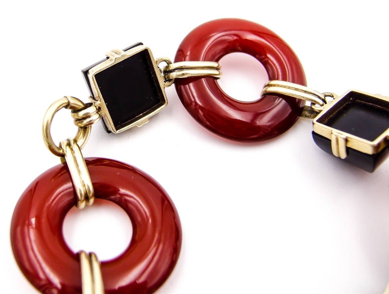 An interesting and wearable bracelet from the late 1920s.  Umber colored donuts of carnelian alternate with perky sugarloaf (domed pyramids) black onyx  elements.   The color contrast is bold and very typical of the color contrasts seen in the late