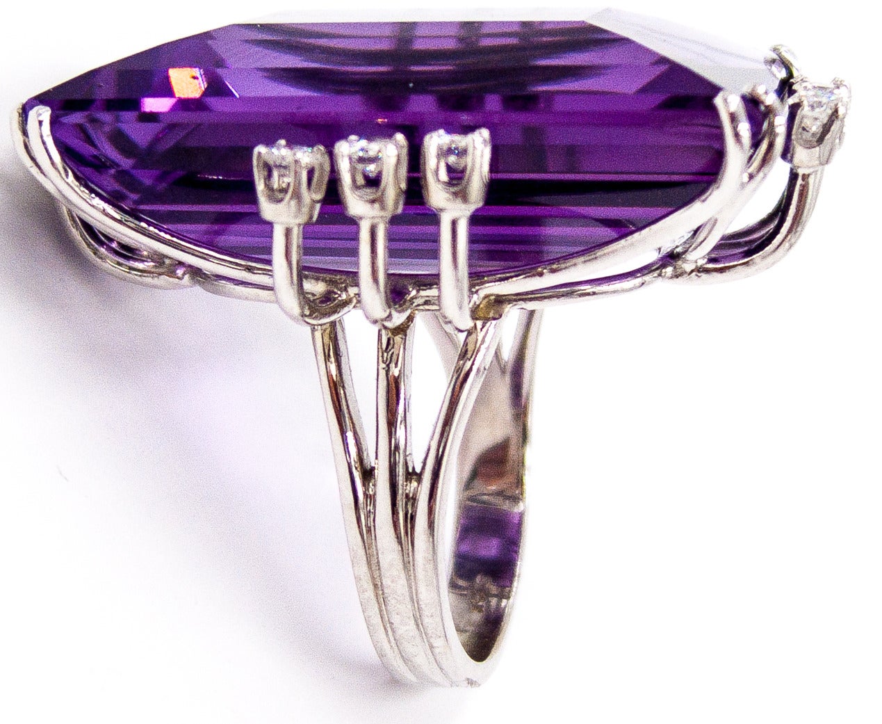 An impressive and elegant ring set in 14 karat white gold  with a large, brilliant, ice-skating rink of an amethyst - approximately 50 carats -  accented on all four sides by petite diamonds.  It's made for a size 7 1/2 finger but can easily be