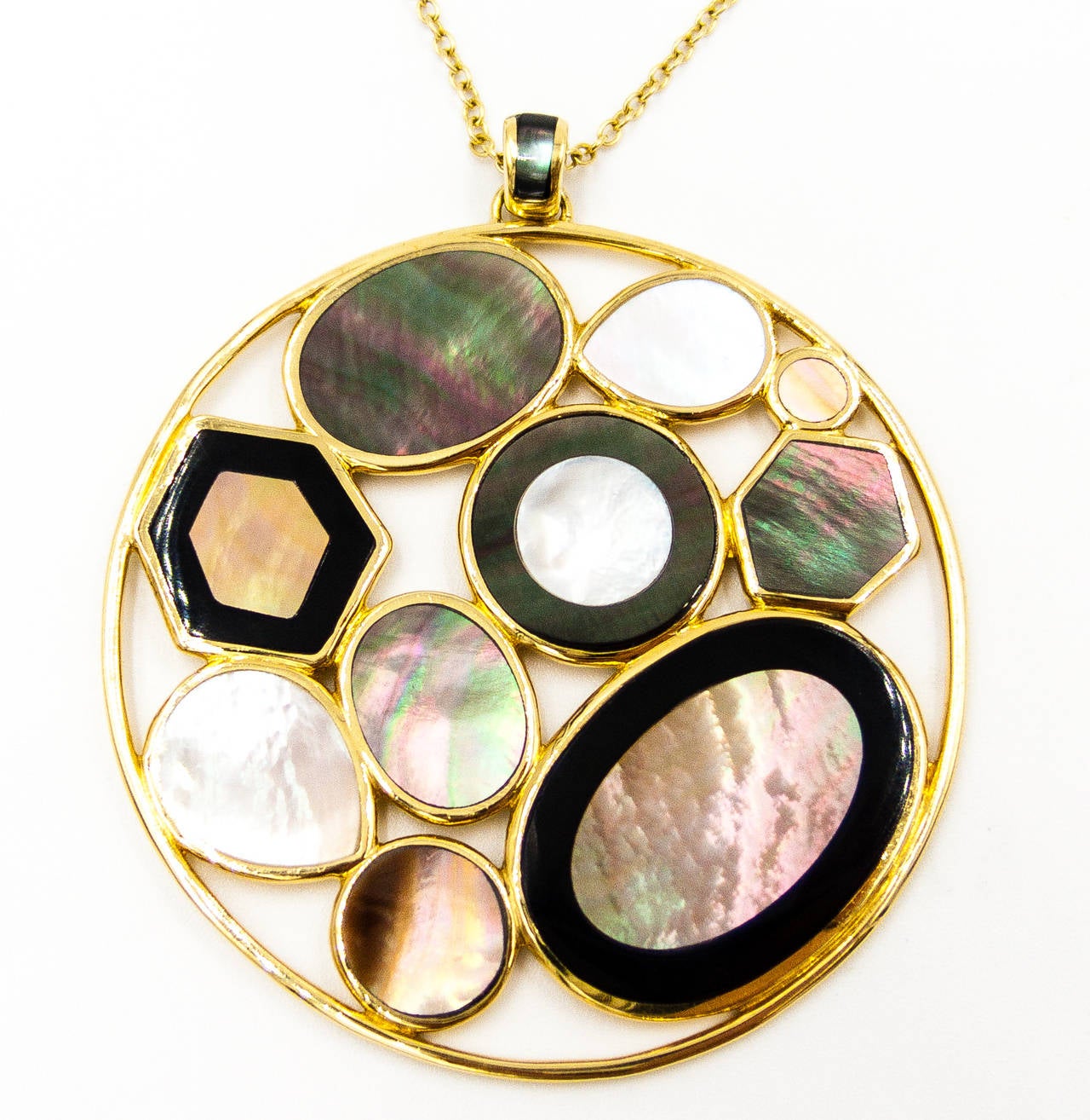 Grey and white mother of pearl set within slashes of black onyx - classic and cleanly geometric, but with Ippolita style.  The pendant itself is 2 inches across, and the chain is of warm and highly polished 18 karat yellow gold - 36 inches in