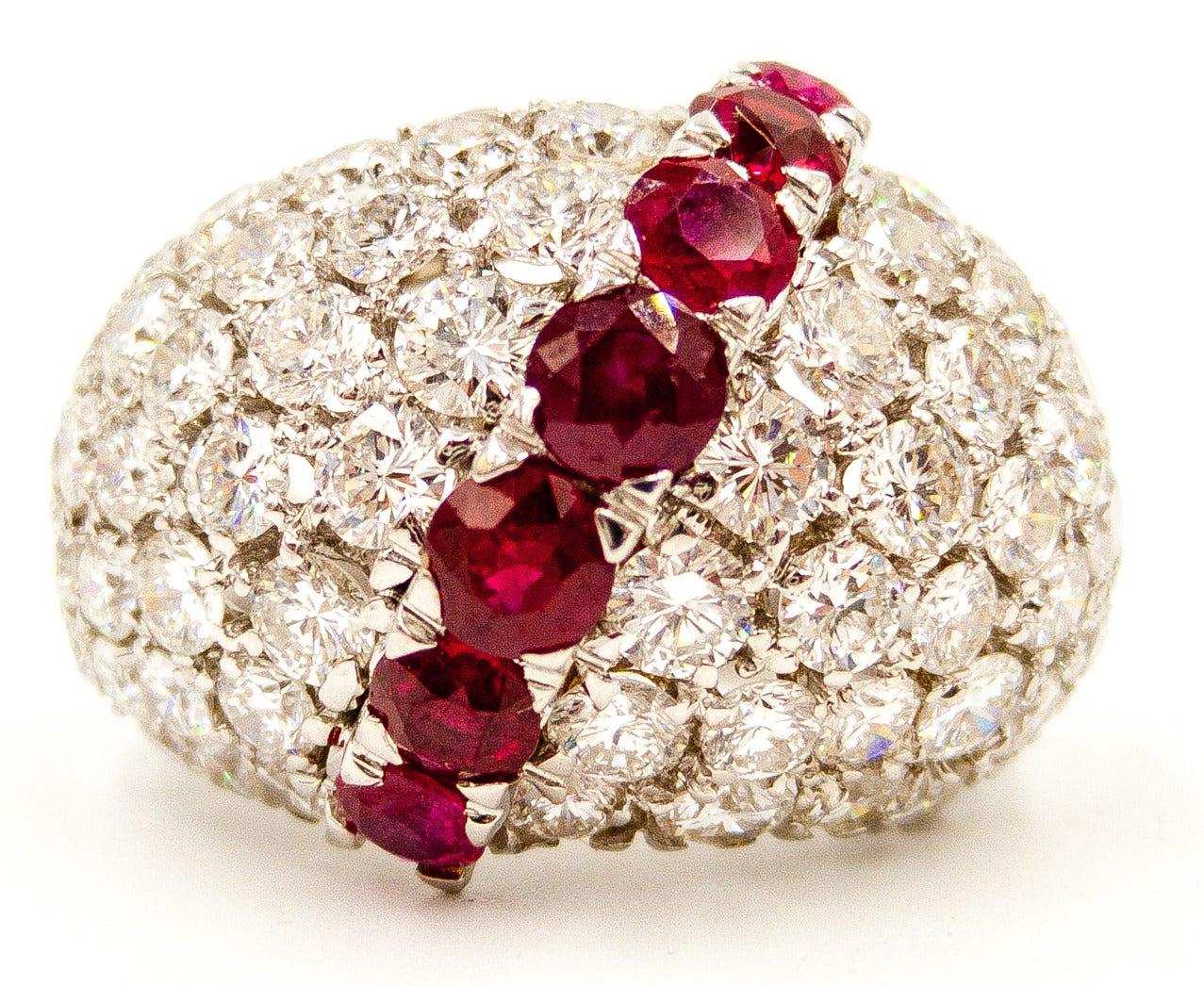 About ten carats of extremely white and clean diamonds domed around the finger, with a line of bright red, sparkling rubies bisecting on the diagonal.   Mounted in platinum, of course.  Currently size 7 1/4 but can be sized to fit up or down.