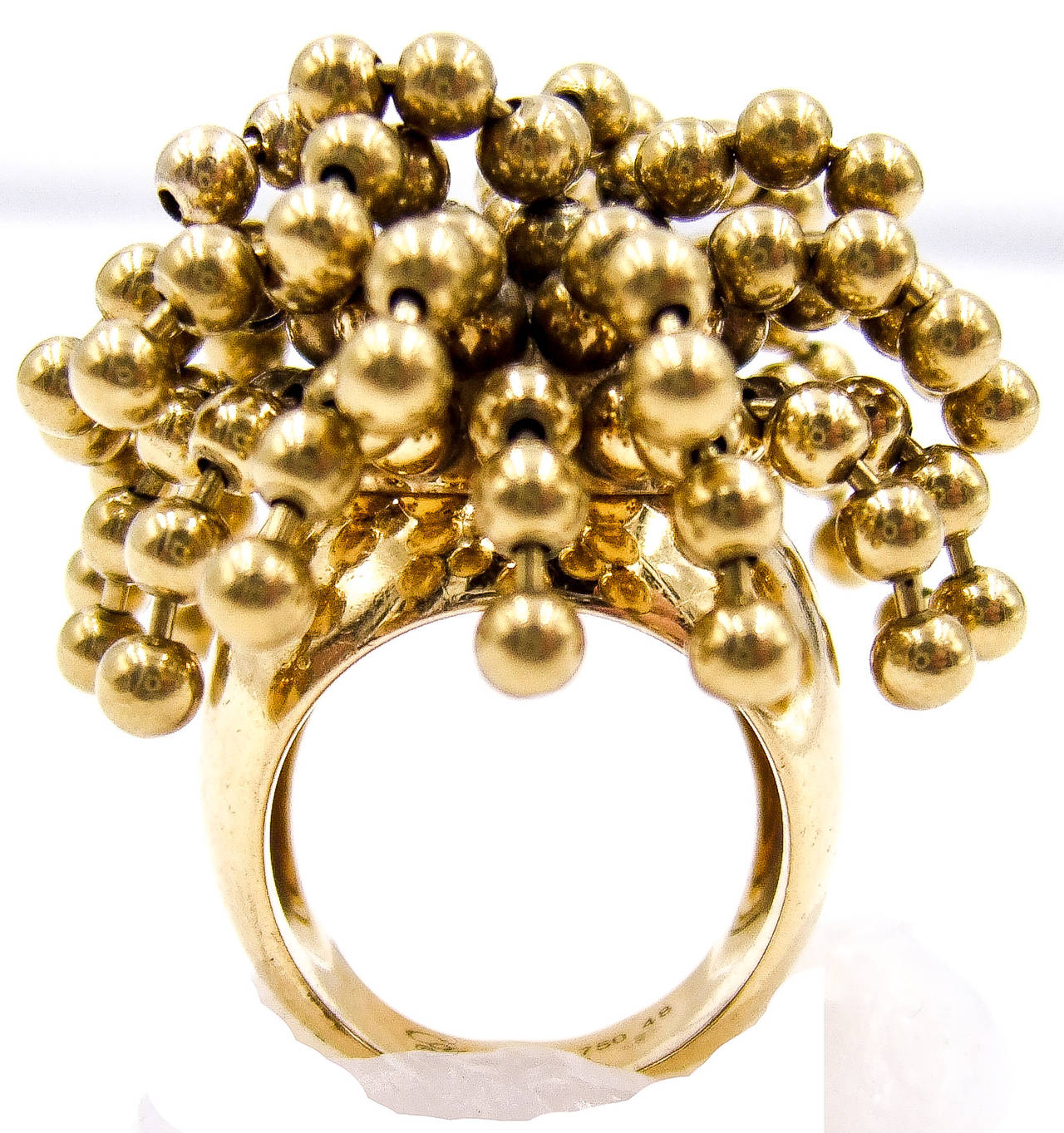 A delightfully amusing ring, with the quality and elegance so inherent in Cartier pieces. The gold balls positioned on golden strands do indeed flip around and move like hanks of hair, so the name 