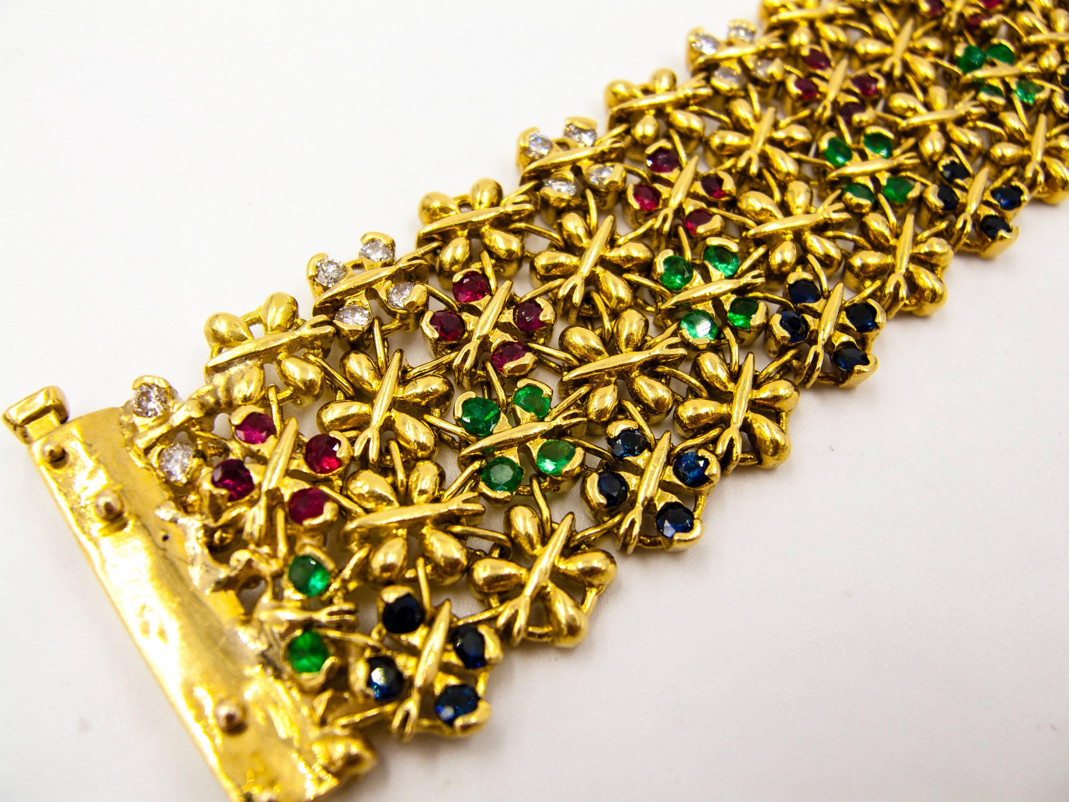   This bracelet has a wonderful, fabric-like quality as it's held in the hand or worn on the wrist.  The petite floral motifs, individually set with rubies, emeralds, sapphires, and diamonds, are arranged in color-organized rows, and the stones are