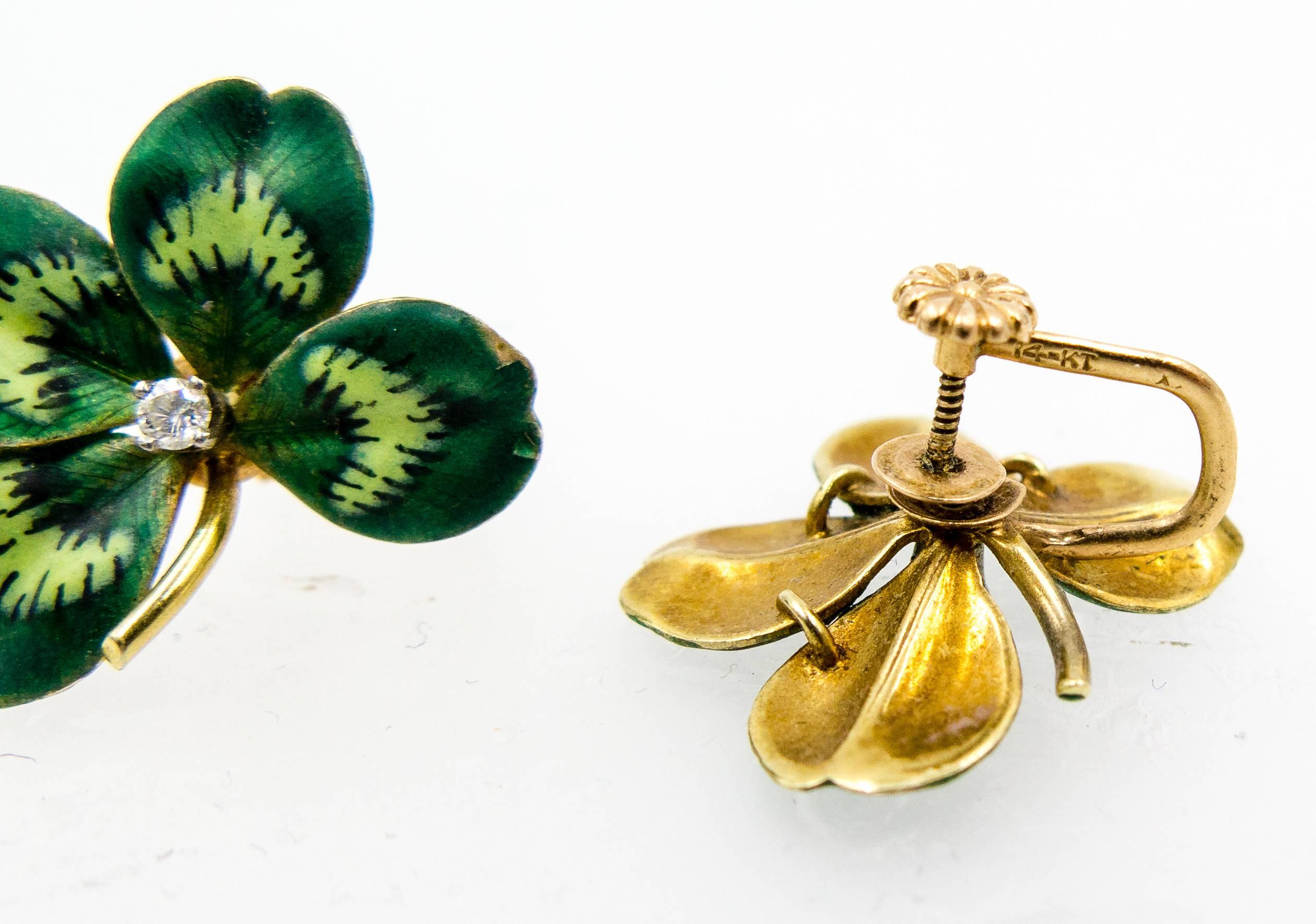 Delightful little suite consisting of a pin/pendant and a pair of non-pierced screwback earrings.   The pin can be worn upside down as a pendant when hung from the swirled gold tube at the rear, and each four leaf clover motif is centered by a