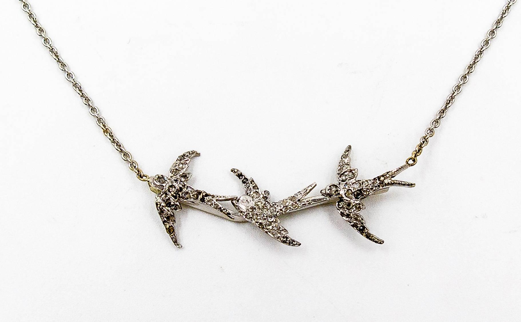    Charmingly unusual and unusually charming, this lovely little necklace is suitable for women of any age.   Three birds, all with outstretched wings, soar across the neck in 14 karat white gold pave set with numerous rose cut diamonds, creating