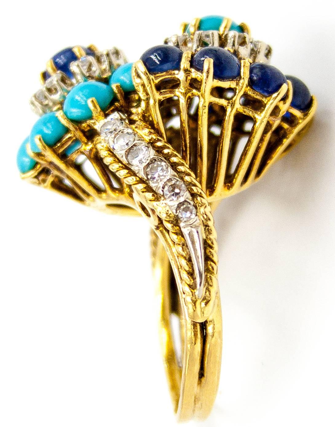A lovely and eye catching ring with perfect colors to brighten any season.   Turquoise cabochons encircle a cabochon sapphire and diamonds, balanced at the other side by the reverse image of turquoise and diamonds surrounded by excellent color