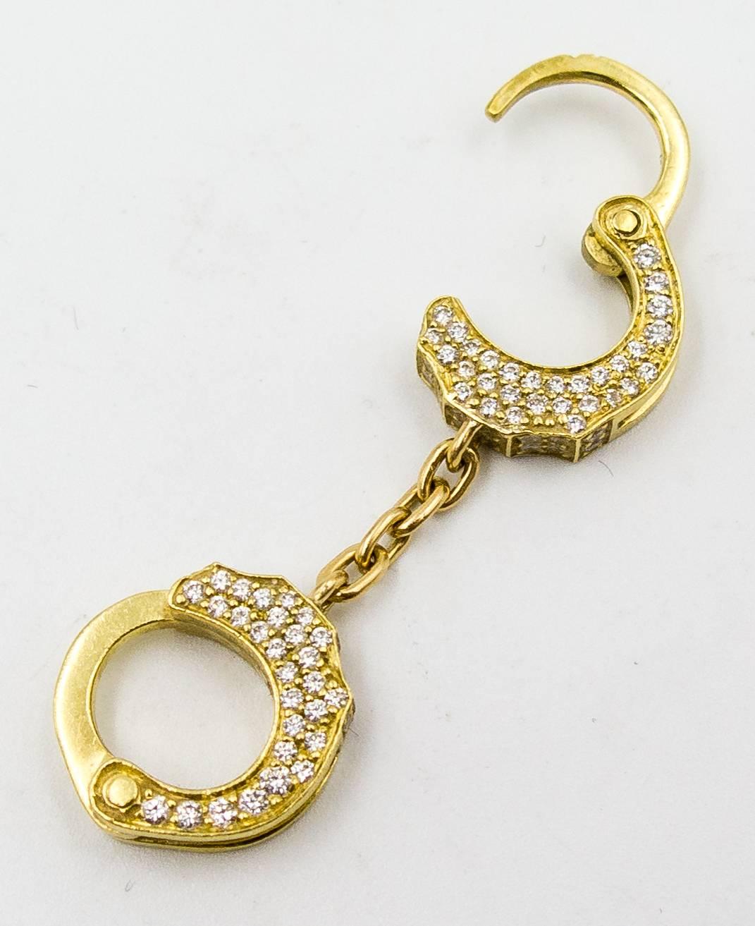 For the buyer with non-traditional tastes, this unusual pendant is worth a second glance.  Crafted in 18 karat gold and pave set with tiny accent diamonds totalling about 1 carat, the cuffs open on one side but remain closed at the other.  The
