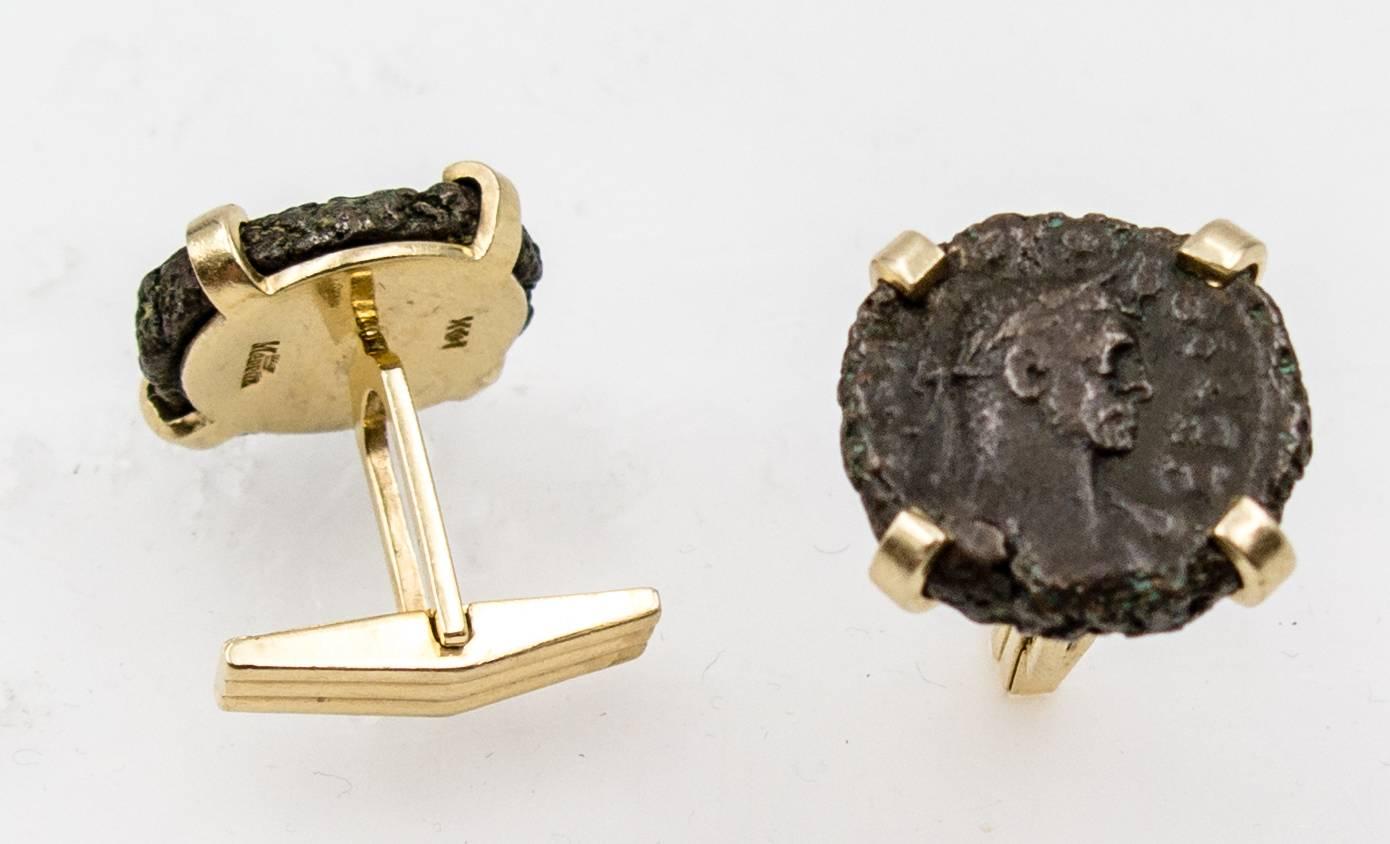  Starkly styled and bold in appearance, these cufflinks feature ancient Roman coins simply set within a 14 karat gold mount with four substantial gold prongs for each coin.   The cufflink operates with a finding that straightens out to enter the