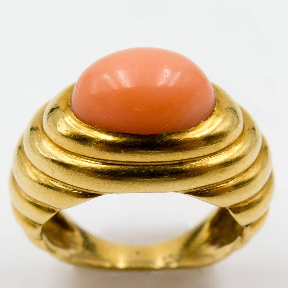 Wir können uns gut vorstellen, dass dieser Ring die  der kleine Finger einer Jetset-Society, die in den 70er Jahren zu einem Fotoshooting nach Ibiza flog.  Der Kontrast zwischen dem rosafarbenen Orange der Koralle und der warmen Fülle der gerippten