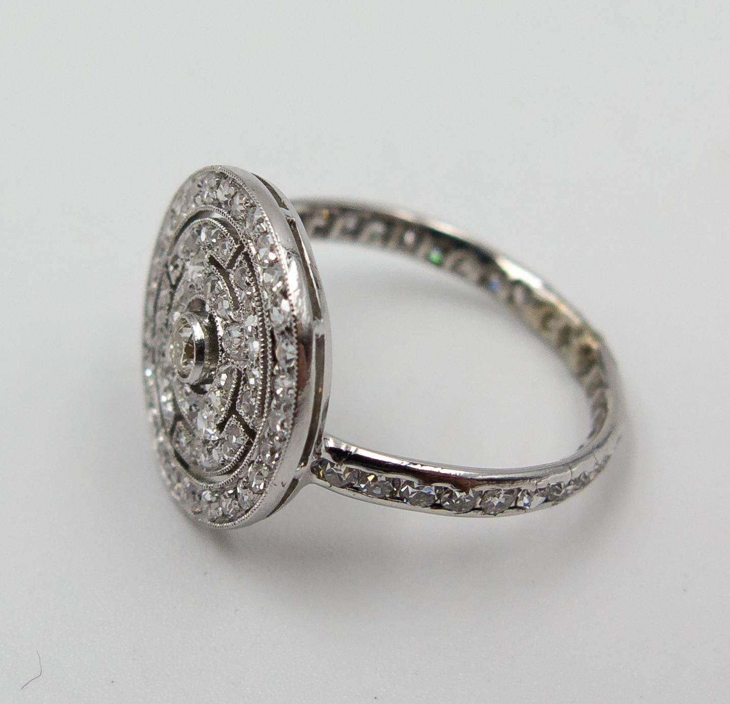   A subtle and wearable ring fitting flush against the skin, this unique little piece consists of a mandala shaped motif pave set with petite diamonds.   The ring is a size 5 1/2, and we like the unusual touch of the diamond shank as a base for the