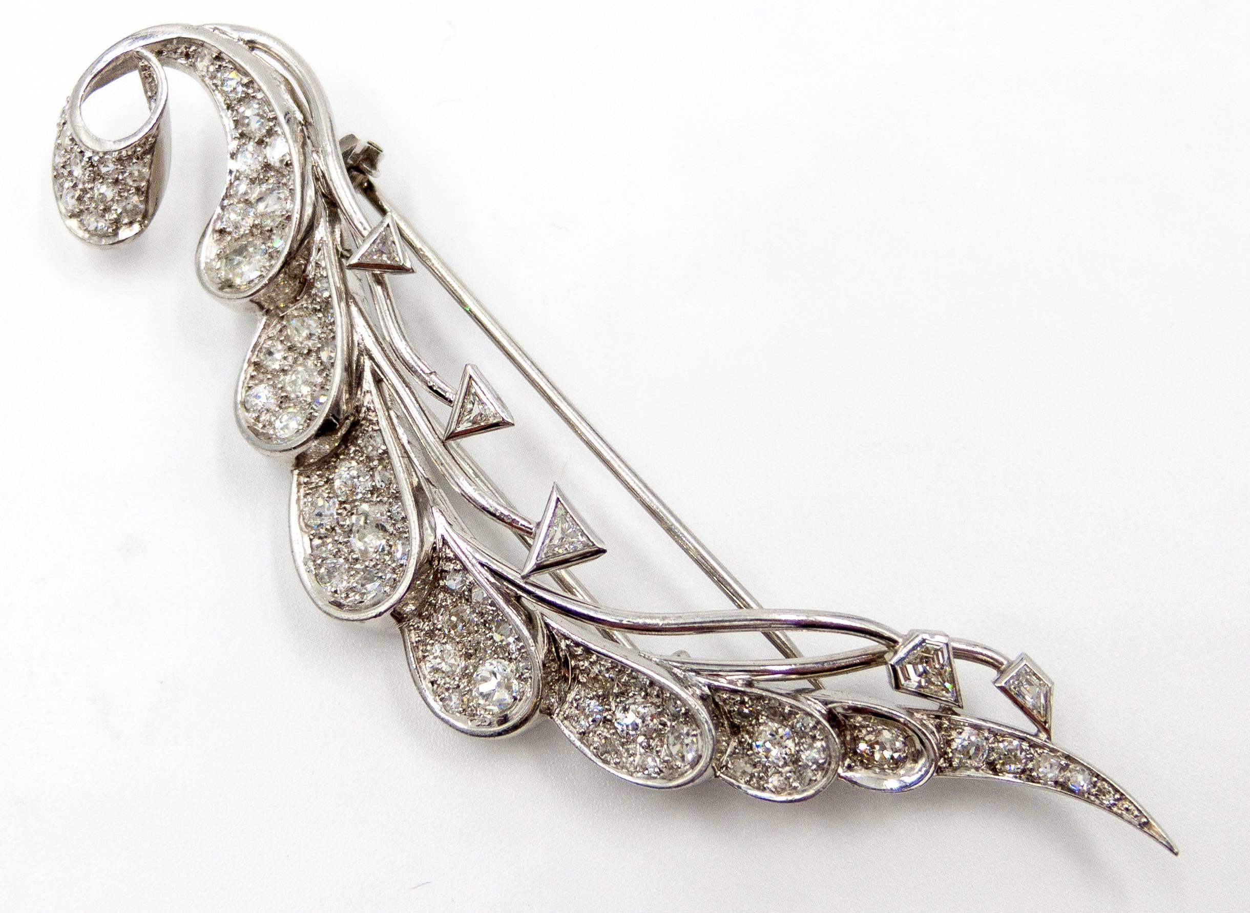A gracefully swooping pin set with elegantly chunky older cut pave set diamonds accented at the edge with geometric triangle diamonds.  The pin measures about 3 1/2 inches in length, at at the widest point it measures 3/4".   French platinum