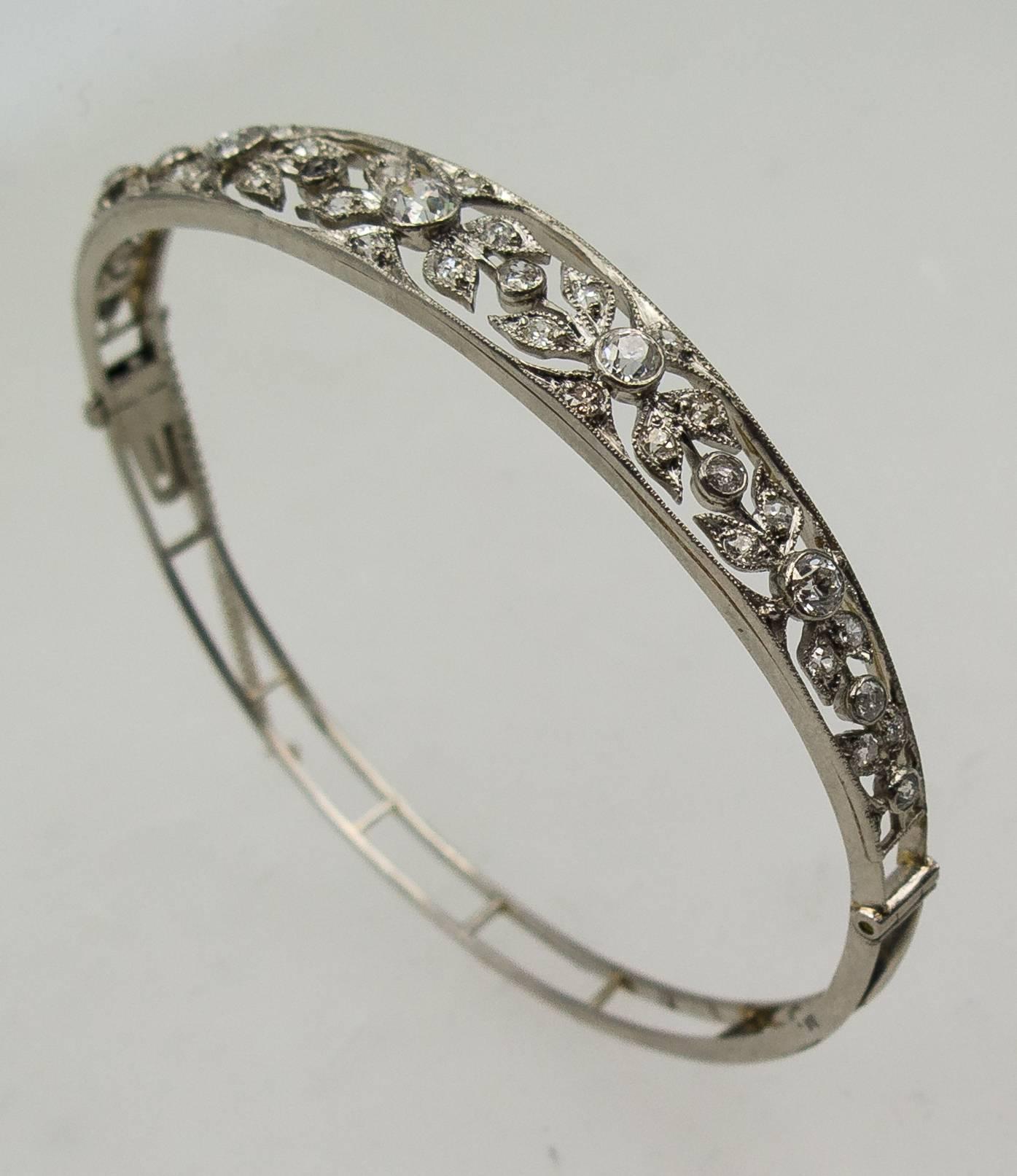   Beautiful and feminine half round bangle bracelet set with older cut diamonds  in an ornate floral filigree motif that spreads halfway around the bracelet.  There's a total of about 2 1/3 carats of diamonds in the jewel, and it will fit the