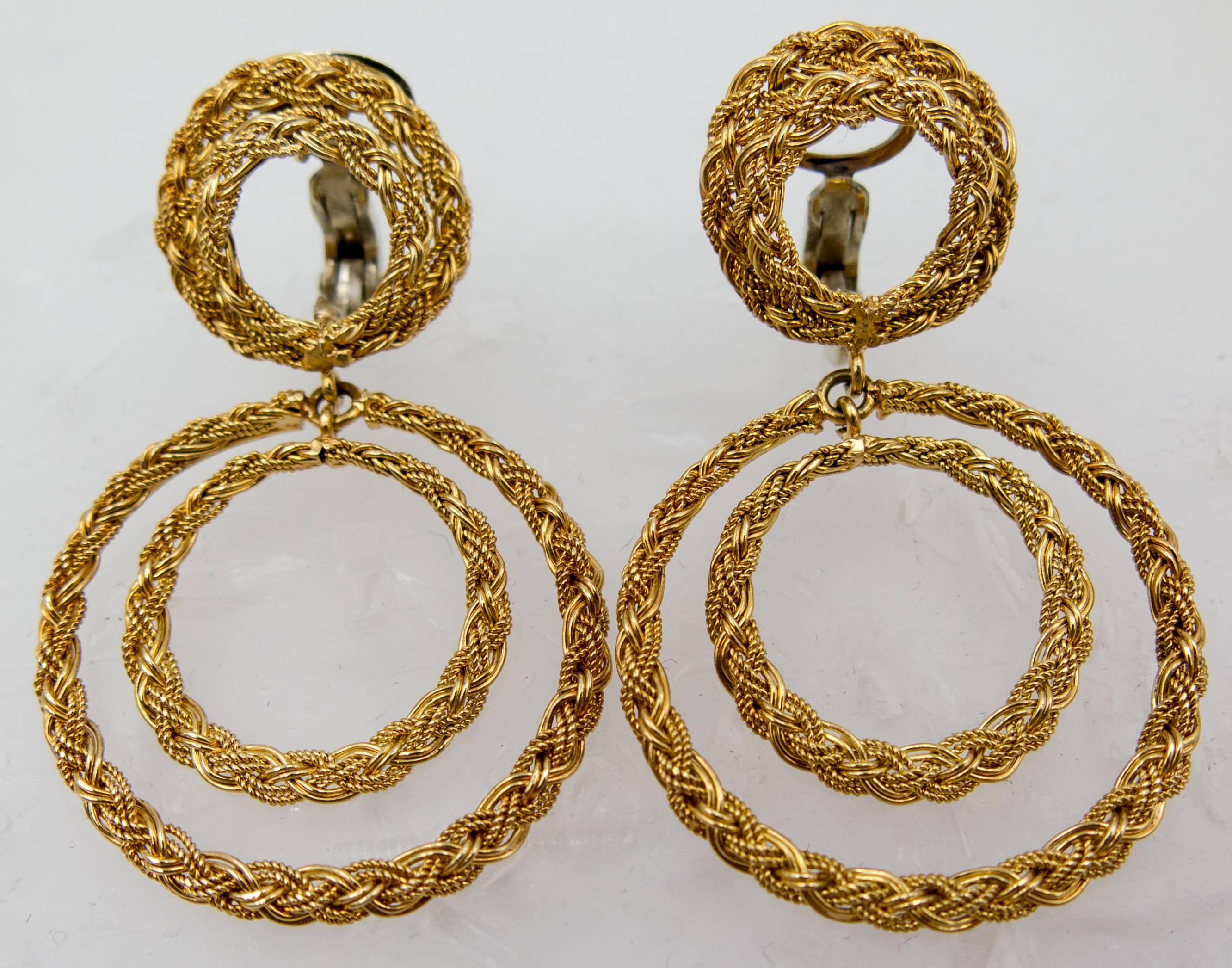 A beautiful and distinctive suite made of smooth and twisted 18 karat yellow gold wires bound together in large, open circles.   The earclips - made for the non pierced ear but can easily be adapted for a pierced ear if necessary - hang down 1 3/4