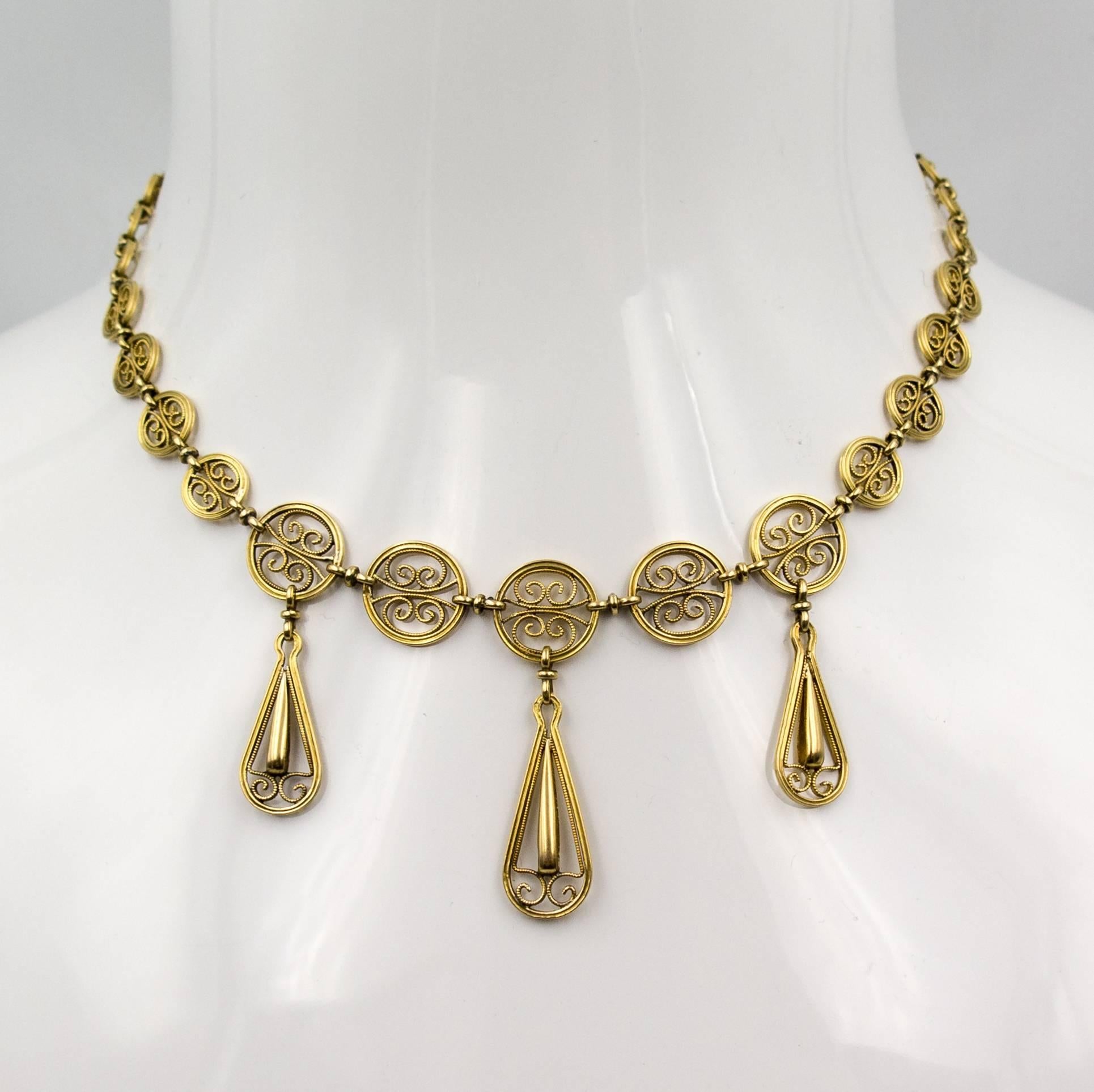 Intricately scrolled filaments of handworked gold form beautiful curlicues to surround the wearer's face.  Crafted in 18 karat yellow gold, the necklace measures  15.75 inches.  