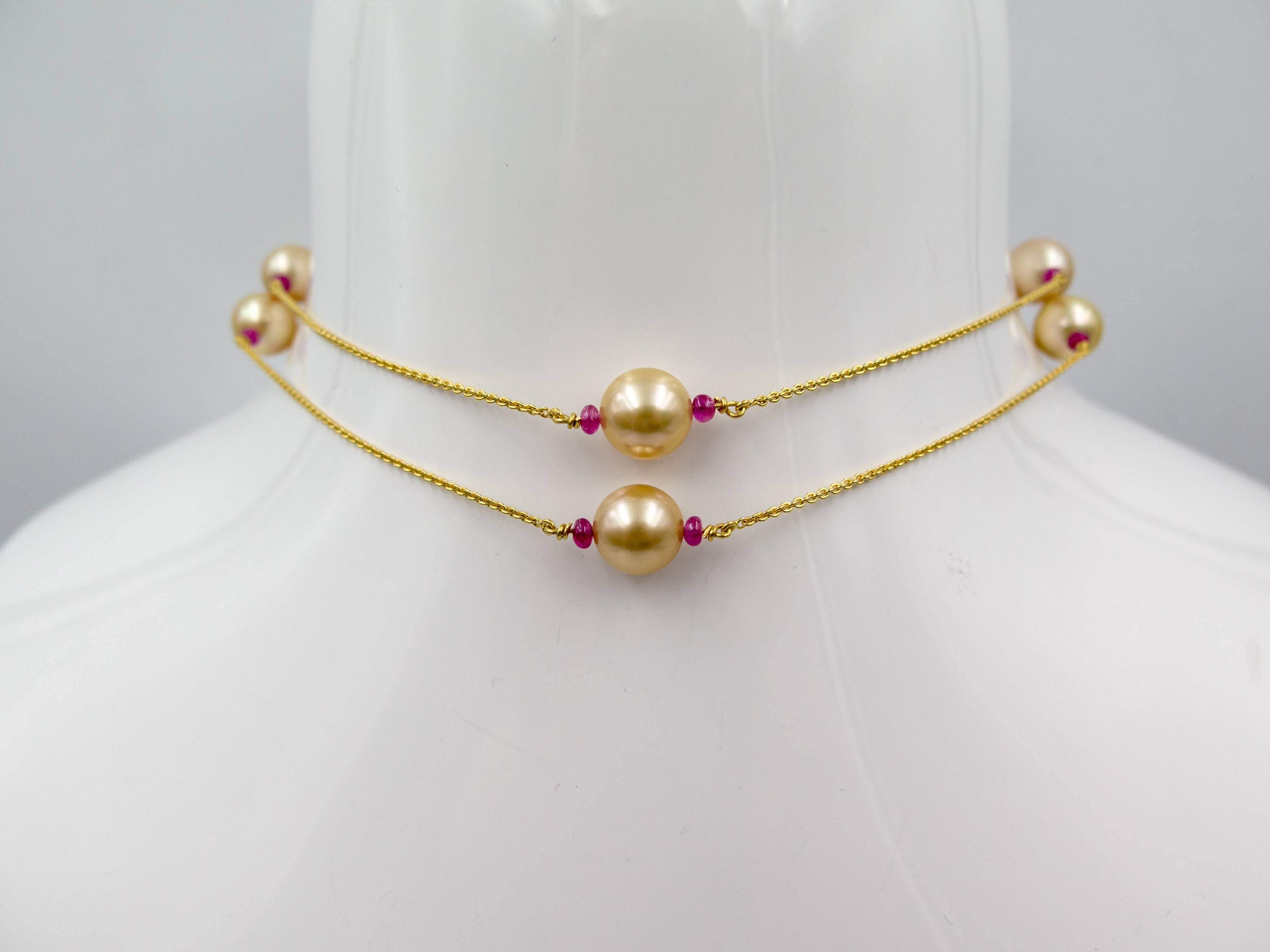 A lovely necklace with a harmonious ensemble of rich 18 karat yellow gold, deeply lustrous golden pearls, all accented with lentil shaped red rubies.   The chain measures 27" in length, and is set with 8 golden pearls measuring about 9 1/2-10