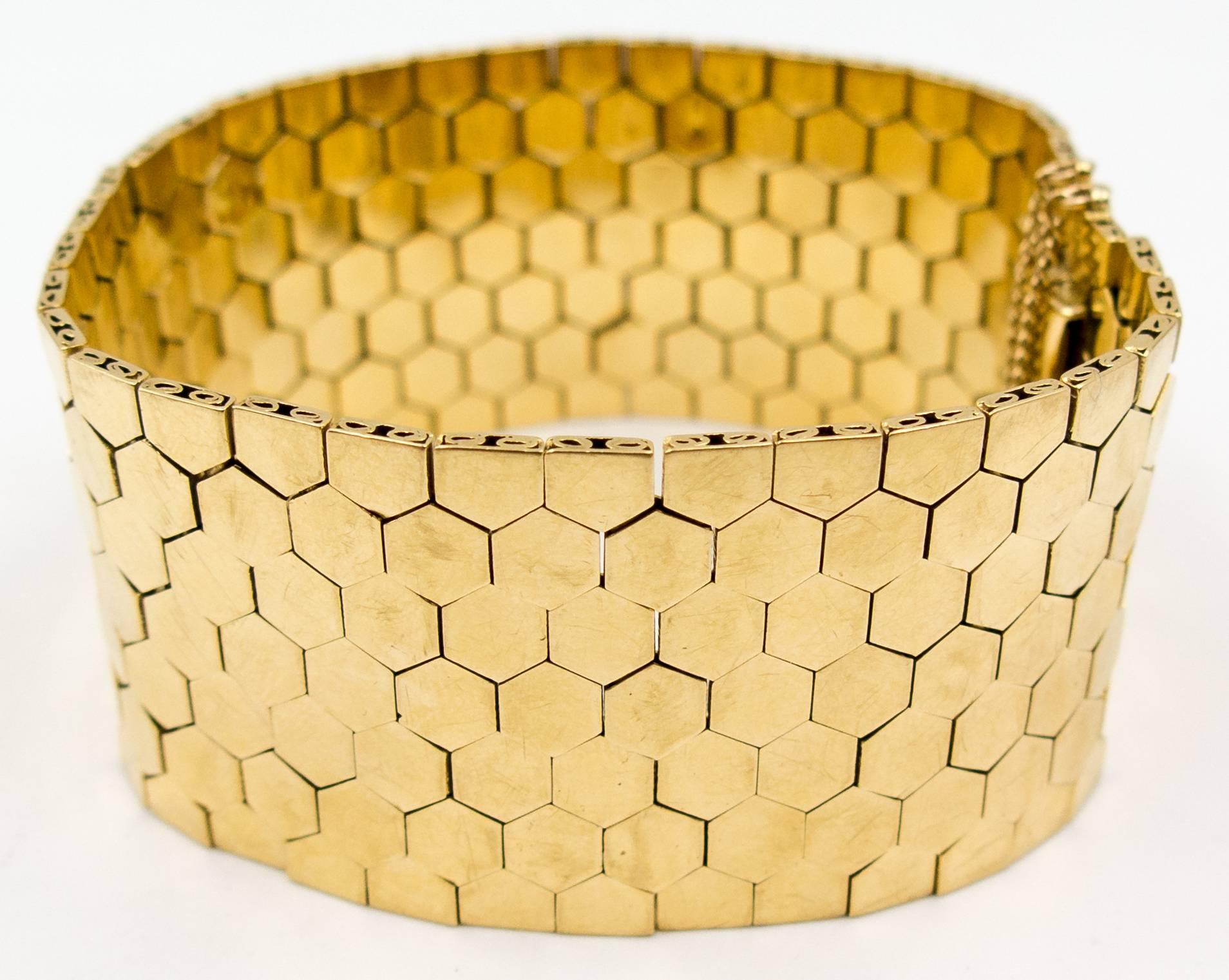 A simple but strongly designed 18 karat gold bracelet of interconnected gold hexagonal plaques that smoothly slide against the wearer's skin.   The bracelet measures 7 1/2 inches in length and is 1 1/8 inches deep, and there's a deeply satisfying