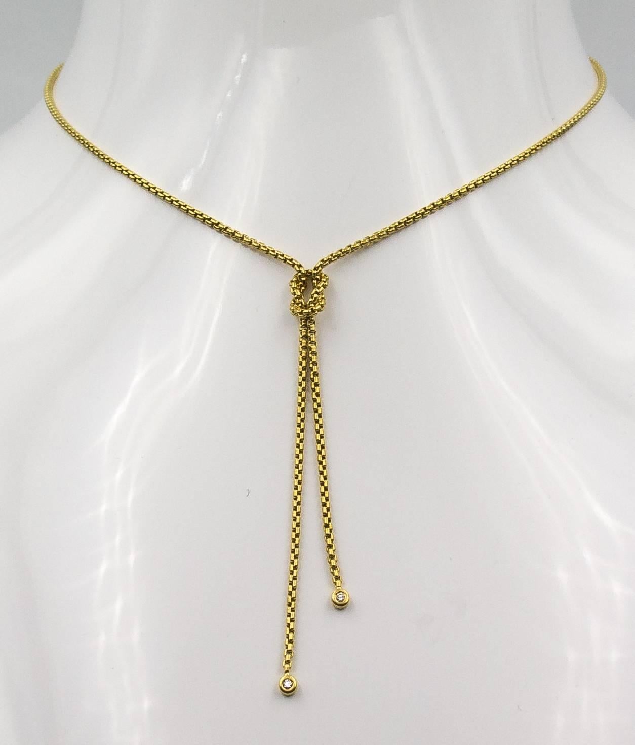 A chic and highly wearable necklace that goes anywhere and everywhere, from the well known designer David Yurman.   It's crafted in 18 karat yellow gold, with a Hercules knot at the base, and two drop chains each containing a small modern brilliant