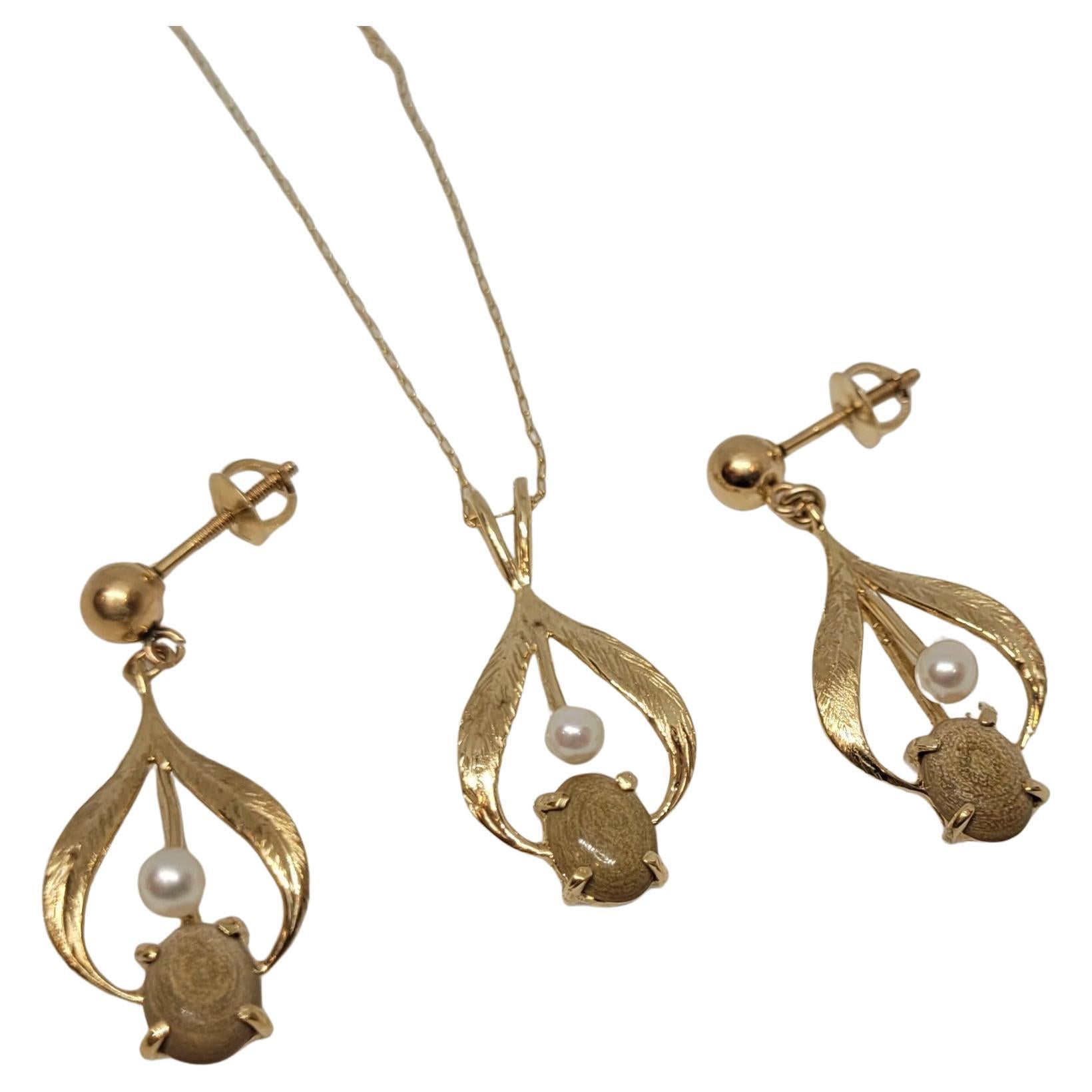 This exquisite set features a pair of earrings and a necklace, both crafted from 14k yellow gold, showcasing a stunning, cohesive design. The earrings are elegantly suspended, allowing them to dangle gracefully, while the necklace drapes delicately
