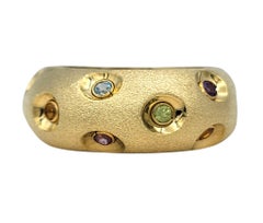 Bague à large anneau et dôme bas, sertie de plusieurs pierres précieuses, en or jaune 14 carats brossé