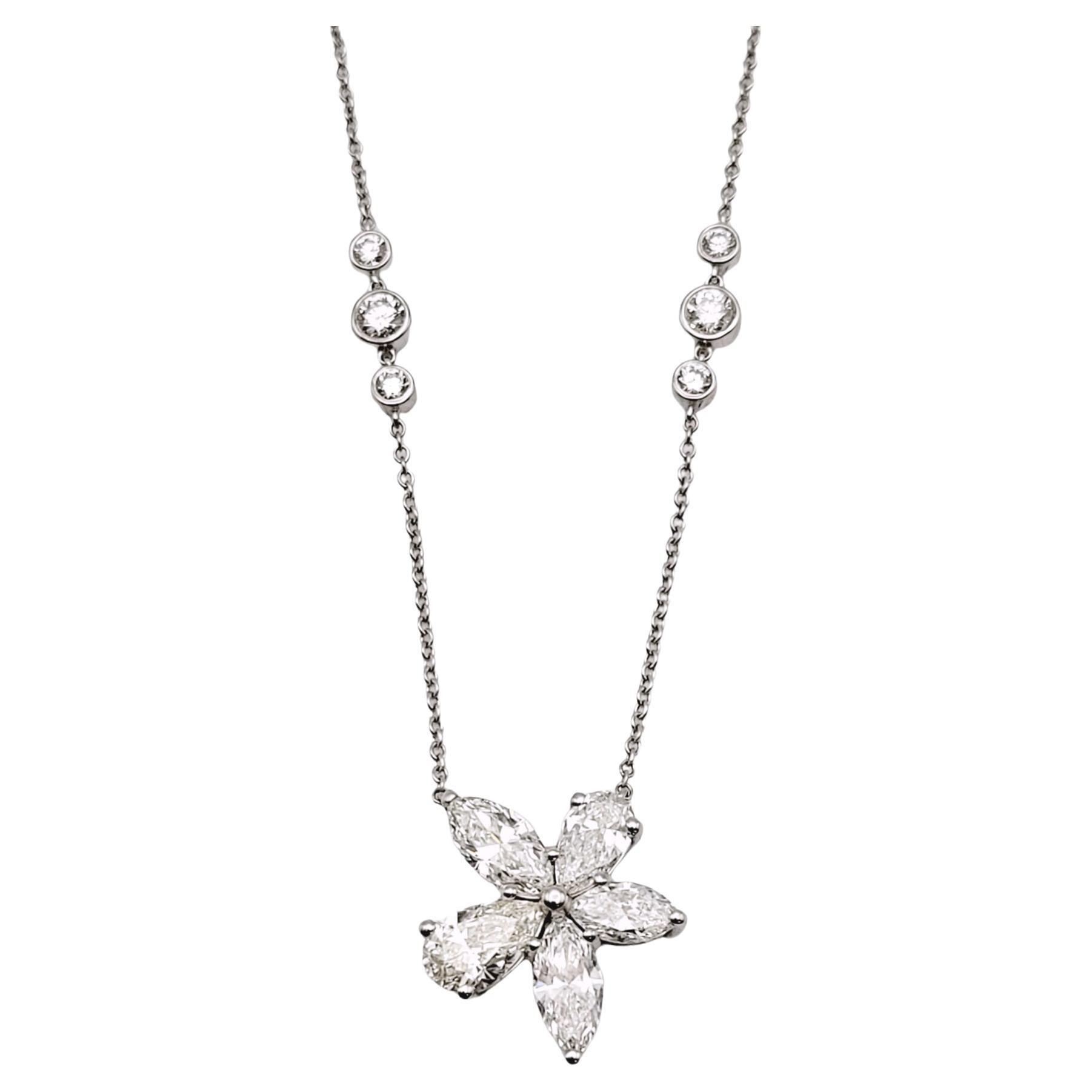 This incredible, ultra feminine diamond necklace by Tiffany & Co. is simply stunning. Part of the popular Victoria Collection, this mixed cluster pendant necklace features several icy white Tiffany diamonds in varying shapes set within a delicate