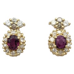 Oval Cut Ruby and Round Diamond Halo Drop Earrings in 14 Karat Yellow Gold