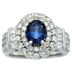 Anello cocktail con zaffiro blu ovale e doppio diamante a raggiera in oro bianco 14 carati