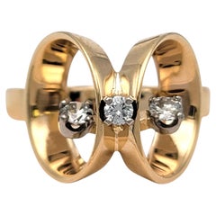 Anello con diamanti per un totale di 0,17 carati, design articolato a profilo alto e montatura a filo aperto, in oro giallo 14 carati