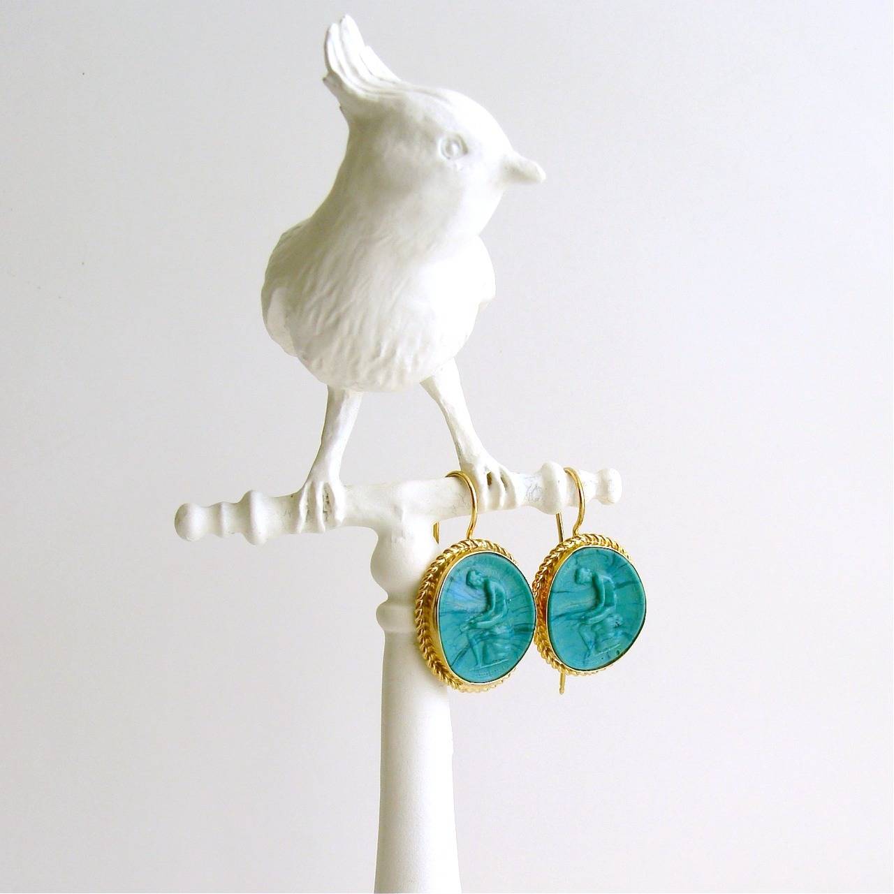 A stunning pair of malachite green intaglio/cameo earrings, with wispy veins of azurite blue, have been surrounded by a delicate twisted wire bezel.  These unique earrings dangle from elongated ear wires which are artfully designed to latch securely
