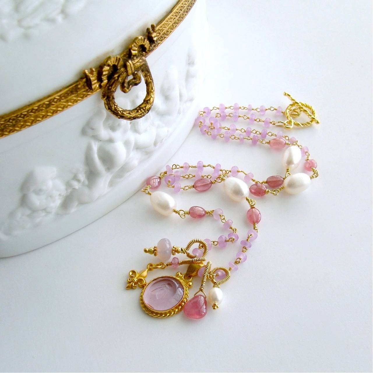 Peu d’Abelle II Necklace.

A dainty gorgeous soft pink Venetian glass intaglio of a Napoleonic bee - becomes the focal point of this classic necklace.  This gorgeous work of art has been married to a delicate necklace of hand-linked orchid