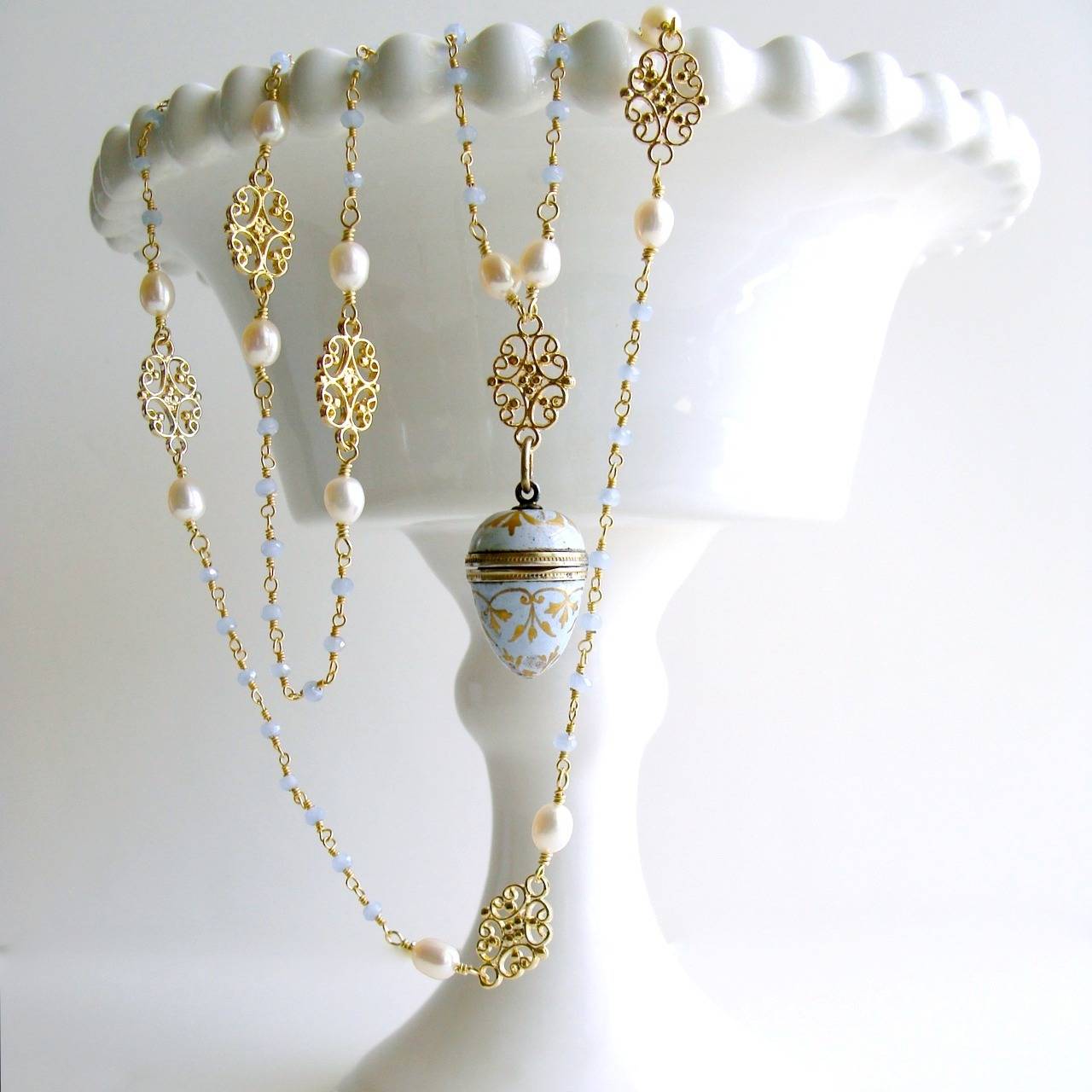 Brezza Dolce III Necklace.

Delicate powder blue hand-linked chalcedony chain is periodically intercepted with stations of creamy pearls flanking a gold vermeil filigree connector to create a gorgeous backdrop for a most charming antique