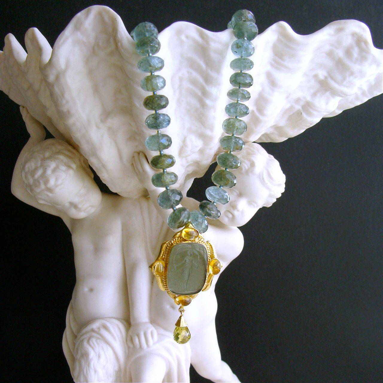 Lissone Necklace.

Stunning moss green sapphire rondelles in shades of loden green and dusty aqua have been married to a beautiful Venetian glass intaglio of a goddess with gossamer dress.  The gold vermeil setting of the intaglio has been