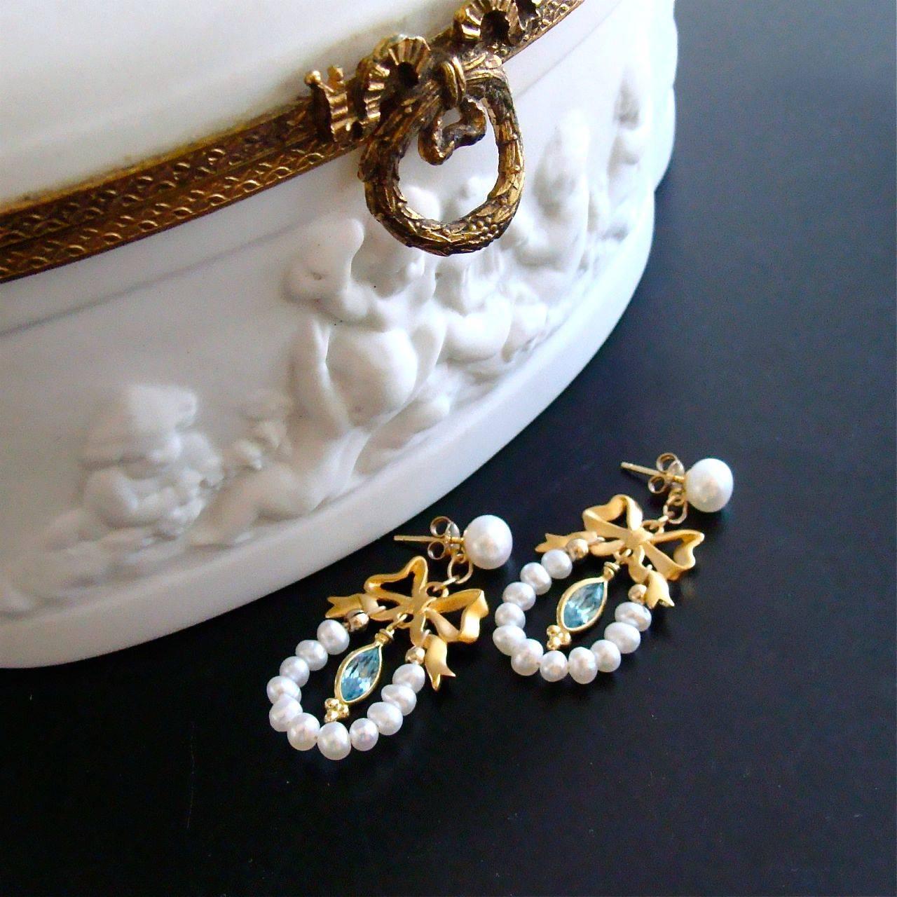 Cassandra Earrings.

Sweet little gold vermeil bows sit perched below freshwater pearl studs and form the easily recognizable Regency hallmark of that era.  Draped below these charming bows, are freshwater button seed pearls - which serve as the