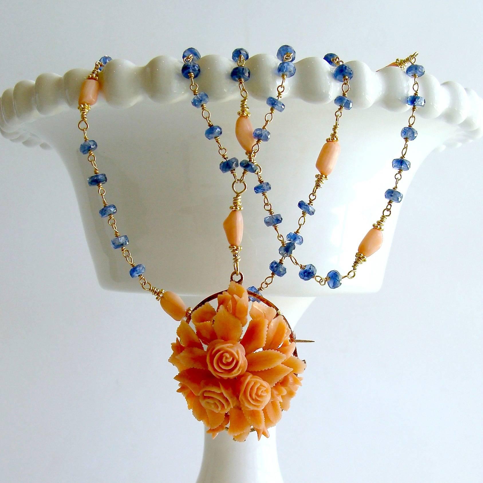 Daphne Necklace.

A gorgeous 14K gold antique hand-carved foliate brooch of delicate peach coral, has become the focal point of this lovely necklace of blue hand-linked kyanite interspersed with gentle coral beads.  The deep water blue of the
