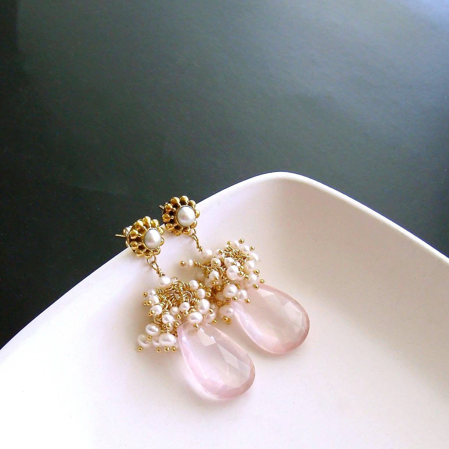 Delicate blush pink and diaphanous faceted rose quartz pear-shaped briolettes are crowned with a frothy explosion of creamy white seed pearls to create a traditional, yet uniquely feminine, pair of  earrings. This ladylike design is suspended from a