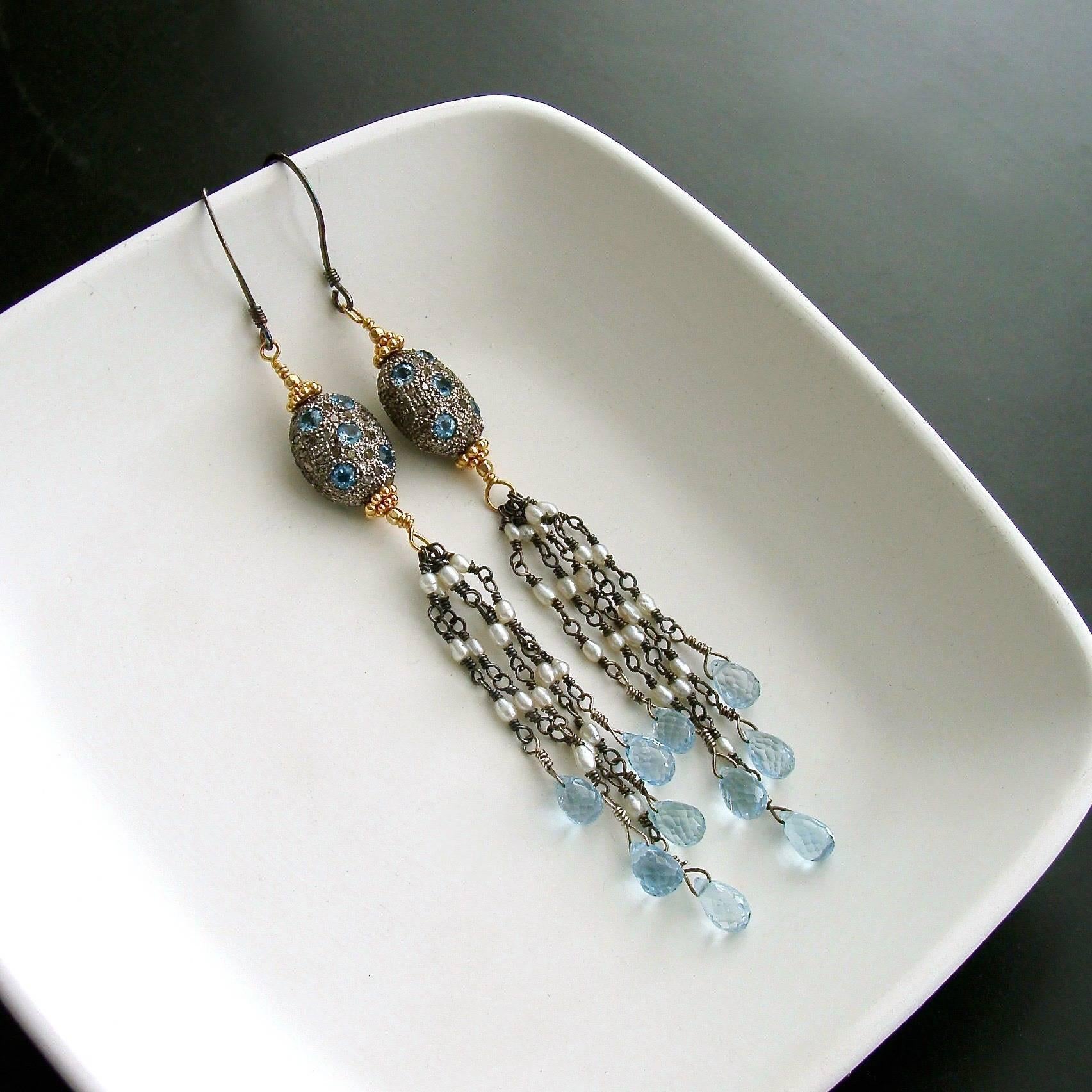 Harmonie Earrings.

Gorgeous pave diamond sterling silver beads, dotted with blue topaz have become the inspiration for these jaw dropping shoulder duster tassel earrings.  The mixed metals of the rhodium silver beads lead one’s eye to a delicate