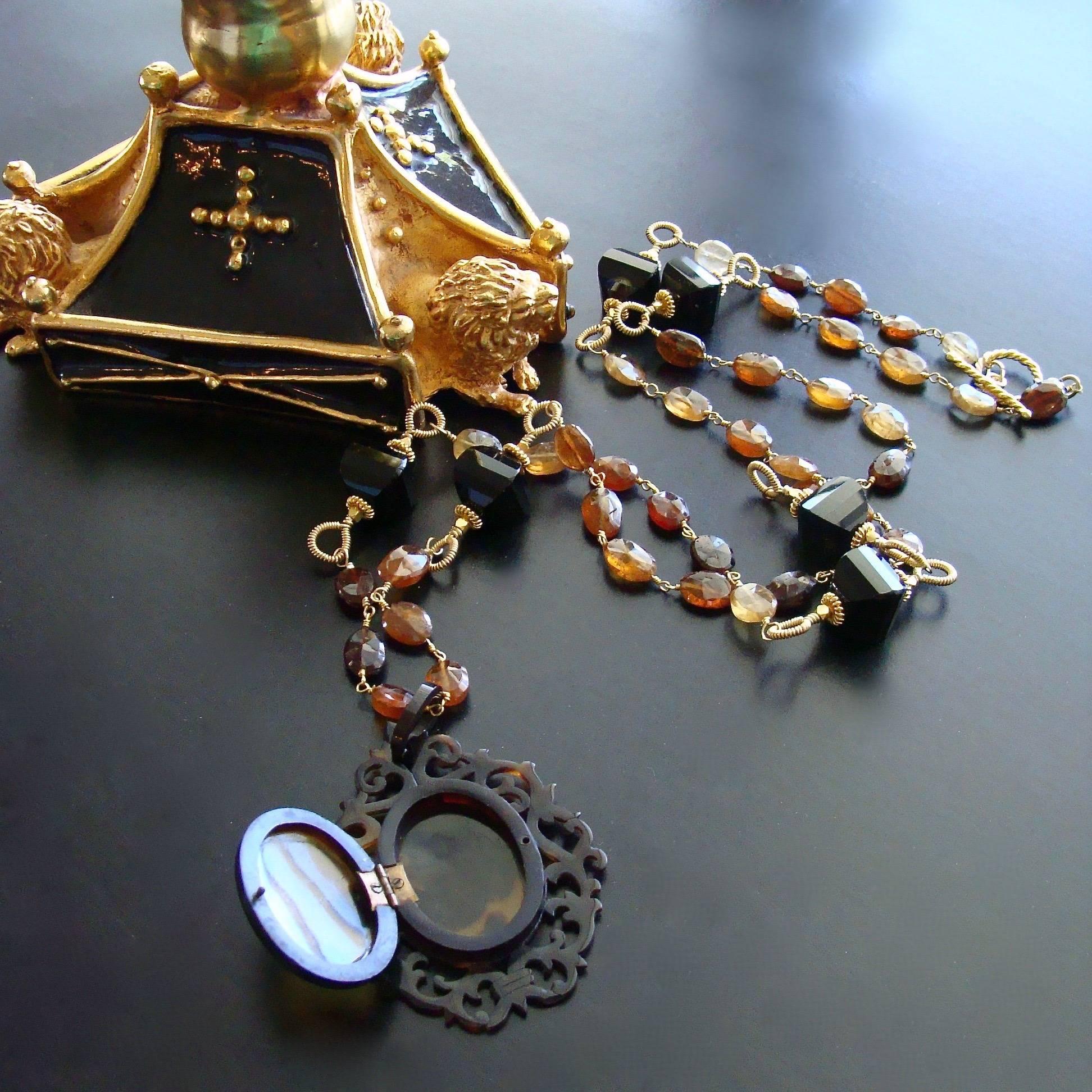 Clarice II Necklace.

A delicate Victorian cartouche embellished Celluloid faux-tortoise antique locket is married to a hand-linked necklace of hessonite garnet with hand-coiled onyx lantern beads stationed along the chain.  This delicate locket 