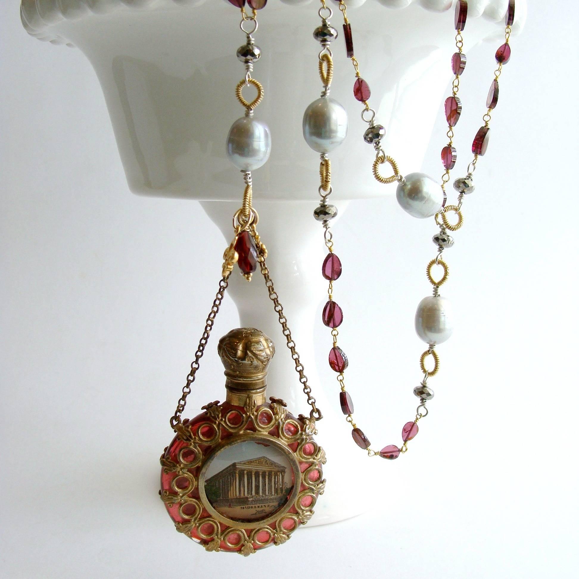 Madeleine Necklace.

Delicate little hand-linked garnet slice teardrops have been paired with white pyrite rondelles flanking hand-coiled baroque gray pearls that are stationed along the chain of this necklace.  This rich and elegant burgundy and