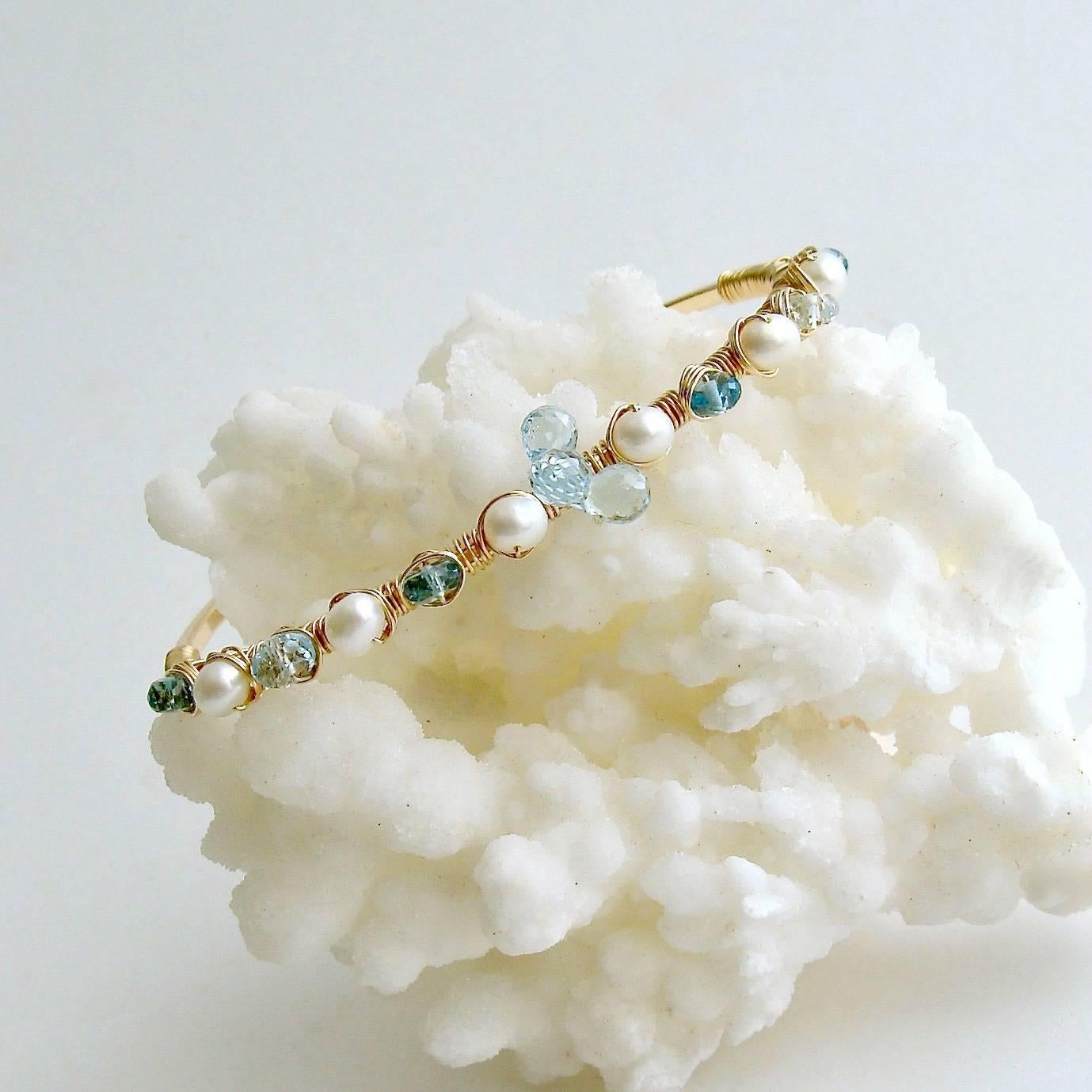 Diana Stacking Bracelet.

A delicate hand wrapped bracelet of 14/20 gold-filled wire is adorned with clusters of sky blue topaz briolettes, cultured pearls and London blue topaz.  These dainty bracelets are not only comfortable and lightweight worn